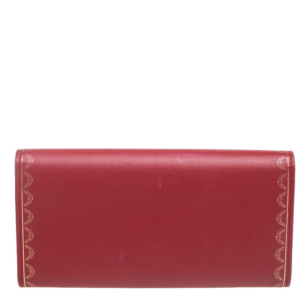 Embody the very definition of restrained elegance and class with this Guirlande de Cartier continental wallet from Cartier. The body of the wallet is made from red leather and a gold-tone design on the exterior. The stunning wallet has multiple card