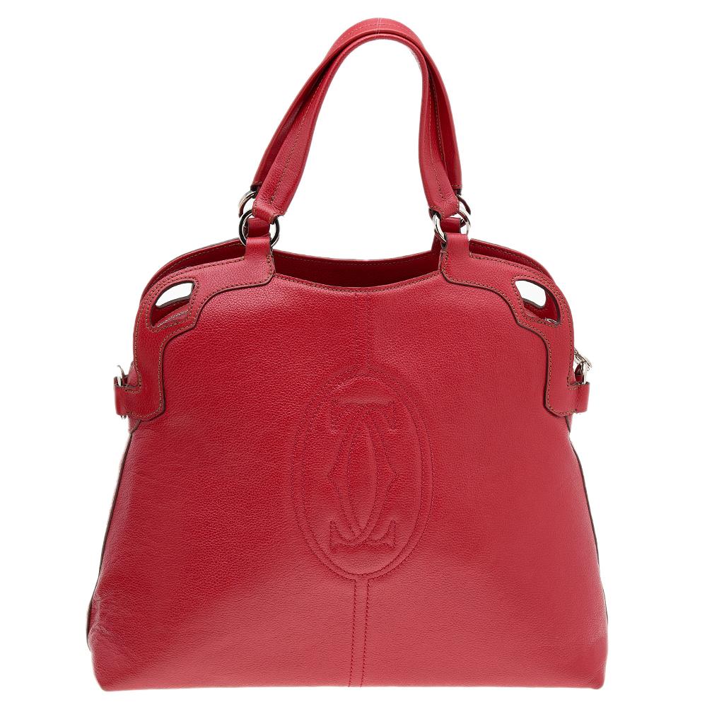 This Cartier beauty arrives in a gorgeous shape and design. It has a red leather body with the logo detailed on the exterior and is held by two handles and a strap. The zipper secures the fabric interior and overall, the bag looks ready to lift your