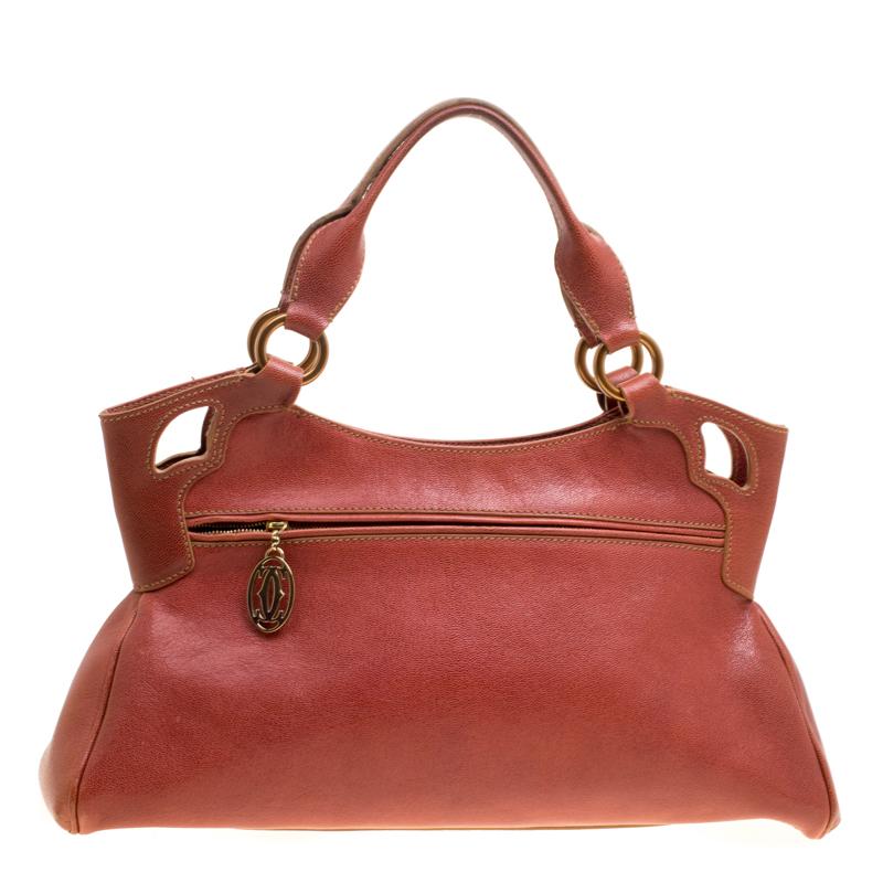 This Cartier beauty arrives in a gorgeous shape and design. It has a leather body with the logo detailed on the exterior and is held by two handles. The zipper secures the fabric interior and overall, the bag looks ready to lift your classic