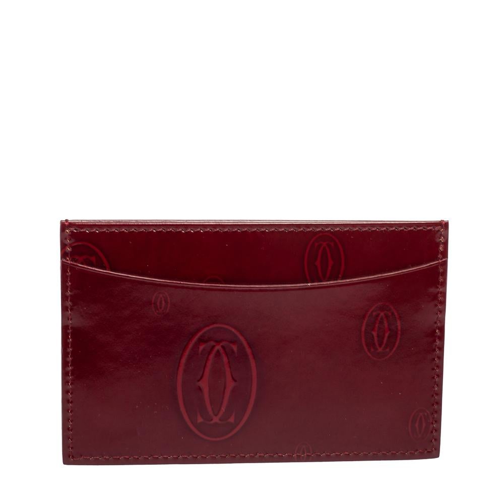 This designer card holder by Cartier is a statement piece. Crafted from signature-detailed patent leather in red, it comes with lined card slots at the front and back.

