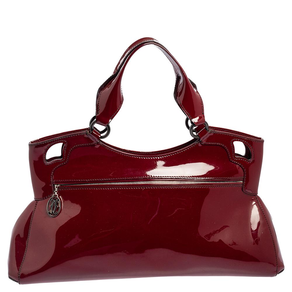 This Cartier beauty arrives in gorgeous shape and design. It has a patent leather body with the logo detailed on the exterior and is held by top handles. The zipper secures the fabric interior and overall, the bag looks ready to lift your classic