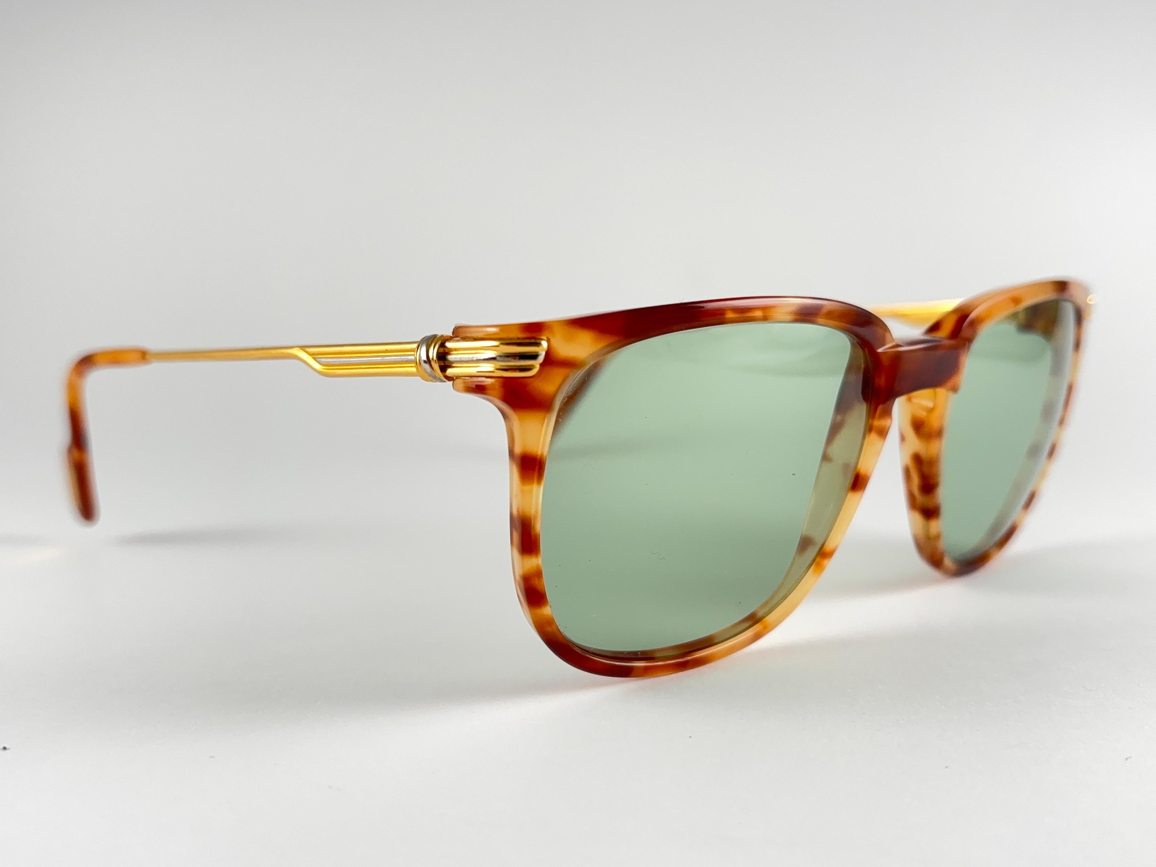 New Cartier Reflet tortoise in the color Jaspe Blond.
Classic sunglasses with green(uv protection) lenses. Frame has the famous real yellow and white gold accents on the temples. All hallmarks. Cartier gold signs on the earpaddles. These are like a