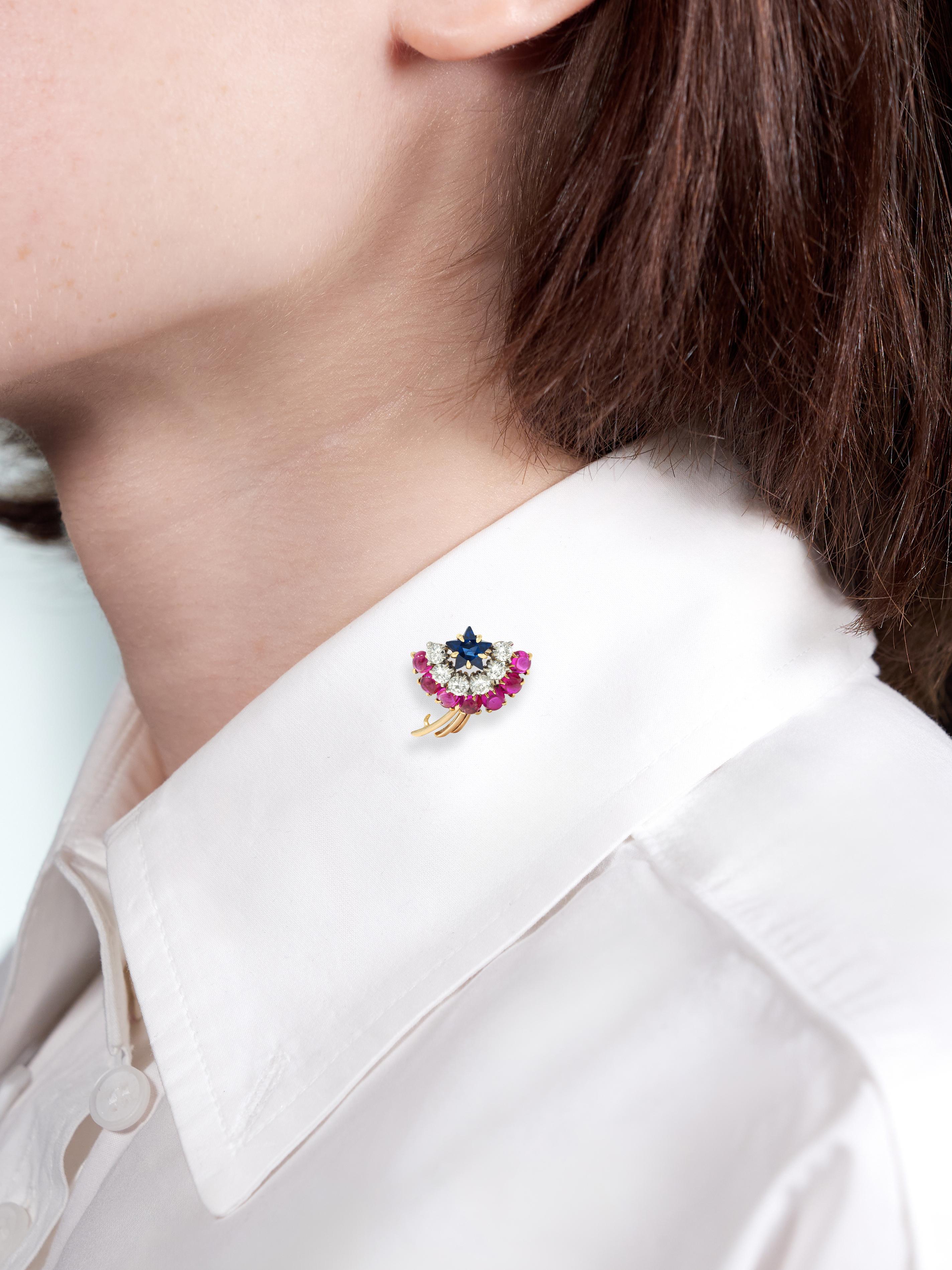 Als Sternschnuppenmotiv mit Edelsteinbüscheln und fächerförmigem Drahtschweif gestaltet
Der Cluster enthält einen Saphir im Sternschliff mit einem Gewicht von etwa 0,45 Karat.
Transparentes Mittelblau und in Gelbgold gefasst
Mit einer halbhohen