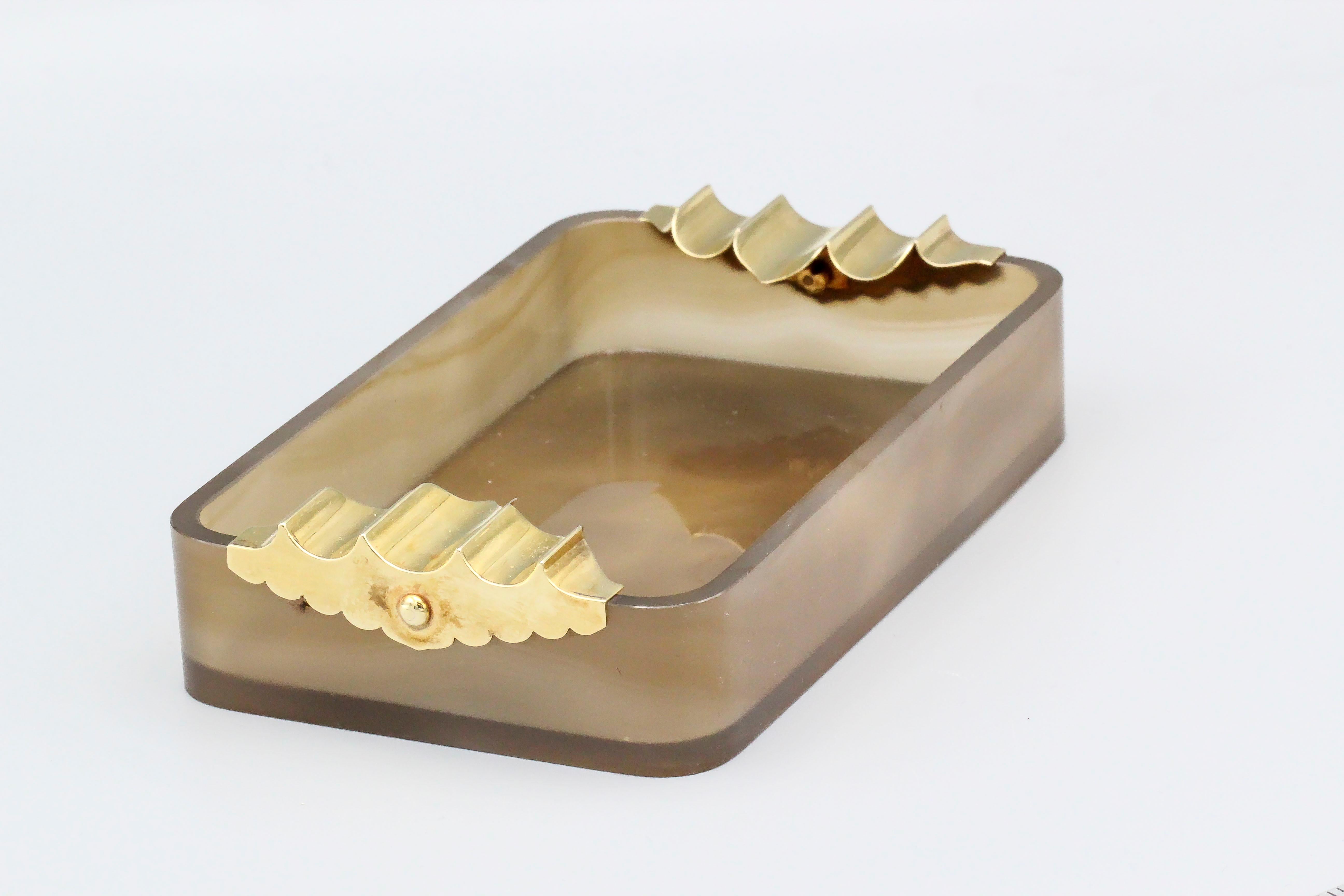 Rare and unusual agate and 14K yellow gold ashtray by Cartier, circa 1940s. It features three gold ribs on each end over a multicolored agate body.

Hallmarks: Cartier, 14K, 