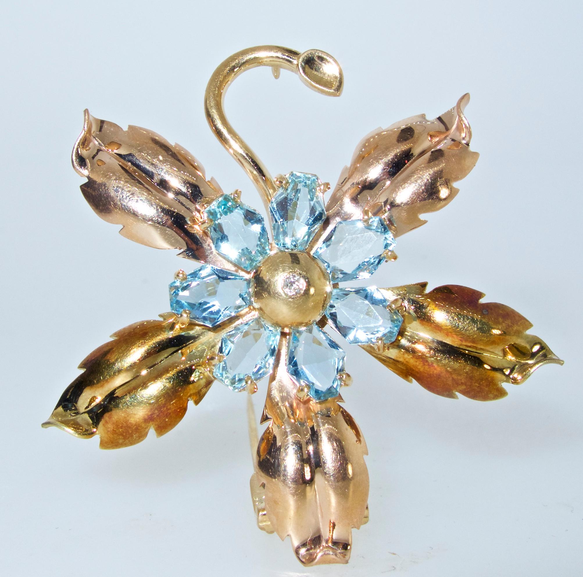 Cartier Retro brooch with 7 fancy cut natural bright blue aquamarines - all bright and well matched.  The total aquamarine weight is approximately 5.6 cts.  The flower bud centers a small white diamond weighing .06 cts.  This double prong brooch