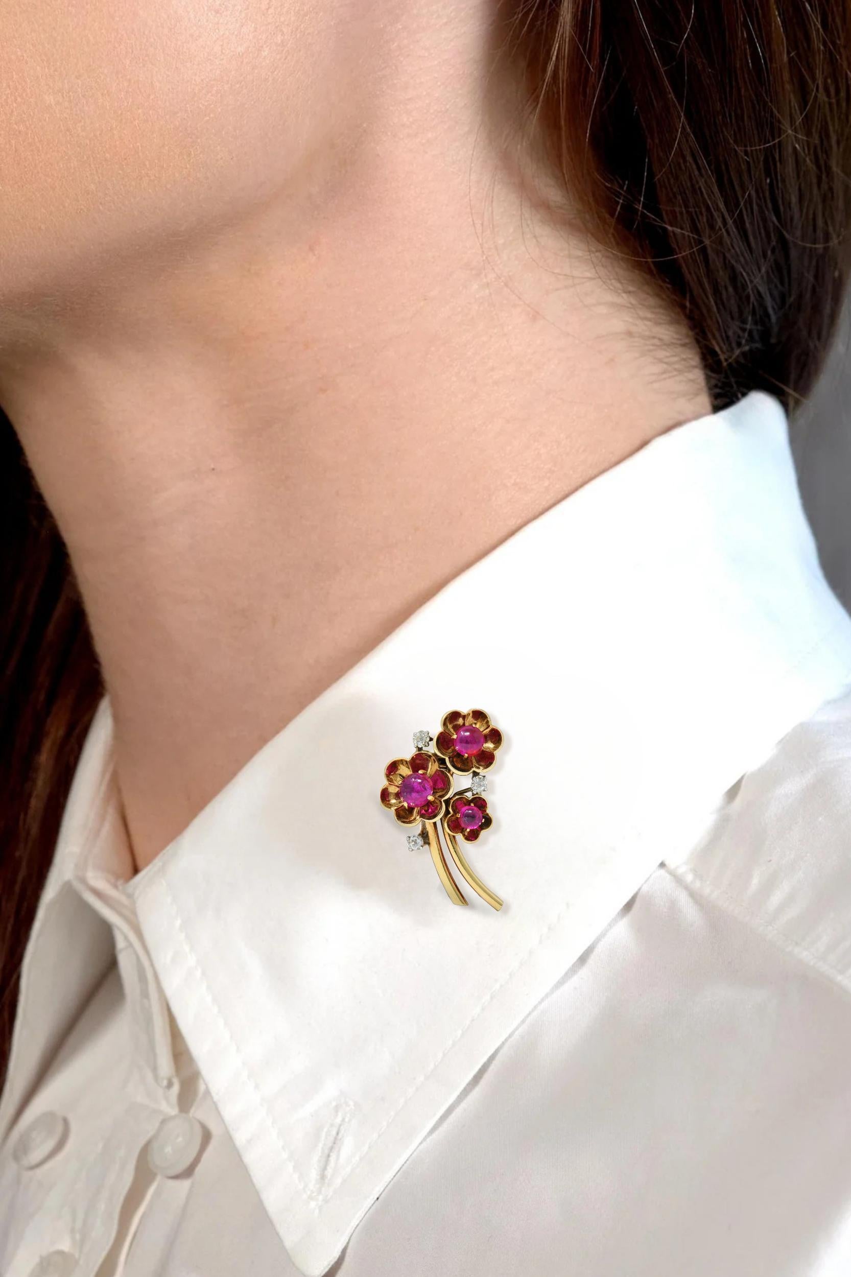 Designed as a bunch of yellow gold flowers with dimensional petals and sweeping stems
Featuring round shaped ruby cabochons prong set as flower centers
Weighing approximately 4.00 carats total - medium purplish red
Accented by old mine cut diamonds