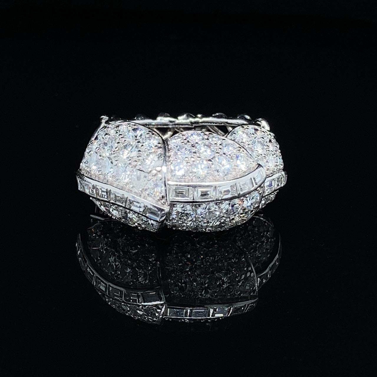 Cartier Retro Diamond Feathers Ring, ca. 1940s

A beautiful Cartier diamond ring from the 1940s. The ring has three central diamond elements following the design of feathers, studded with round brilliant cut and tapered baguette cut diamonds of ca.