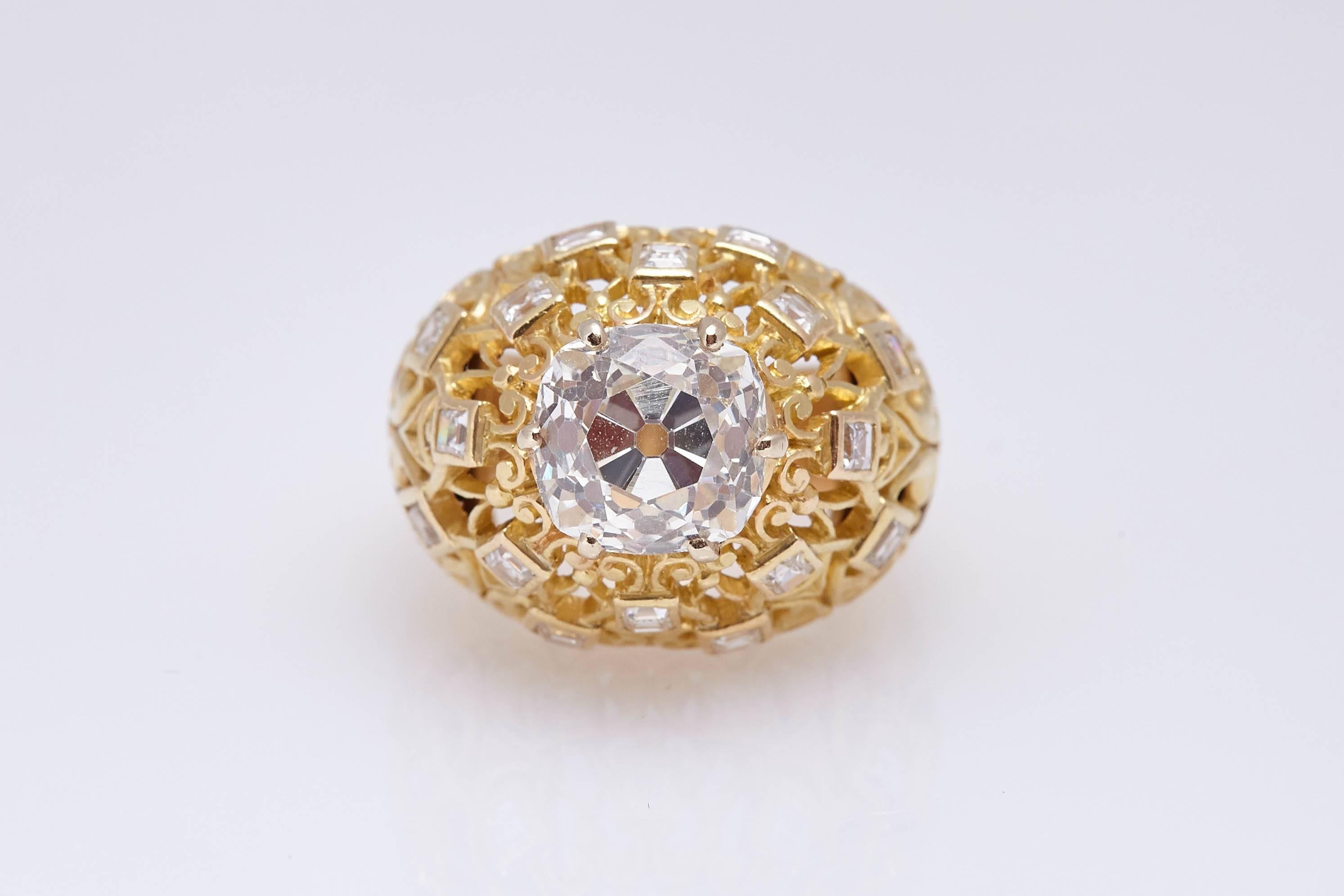 A Cartier retro dome shaped ring in 18kt yellow gold, the mounting embellished with fine round cut diamonds, showcasing an Old Mine Brilliant Cut Diamond weighing 4.24 (L Color, SI1 Clarity - GIA Certificate). Made in France, circa 1950s.