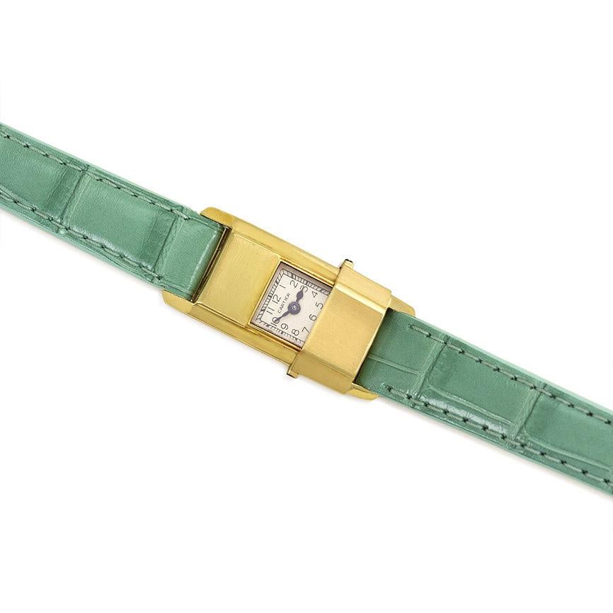 A Retro gold backwinder concealed dial wrist watch with sliding cover, completed by a later sea green alligator band, in 18k.  Cartier, France.

Dimensions of timepiece including lugs: 1 5/16 x 5/8 in.