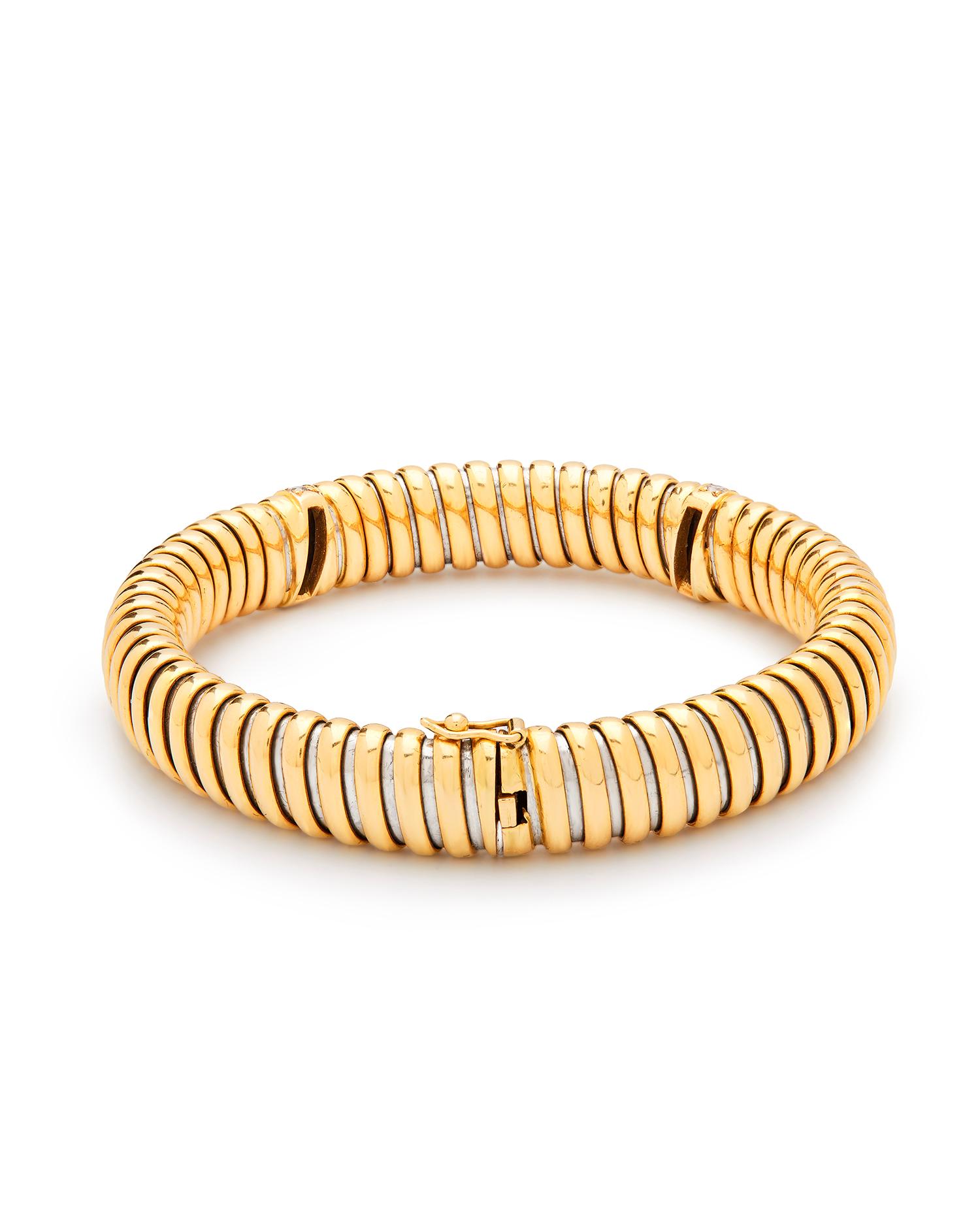 CARTIER: 'RHAPSODY' DIAMOND BRACELET
The front set with two rows of brilliant-cut diamonds, approx. 0.25ct total
Bicoloured gold, white, yellow and rose flexible links with safety clasp.  
Signed Cartier, numbered 969210
Length 19.3cm
Weight approx.