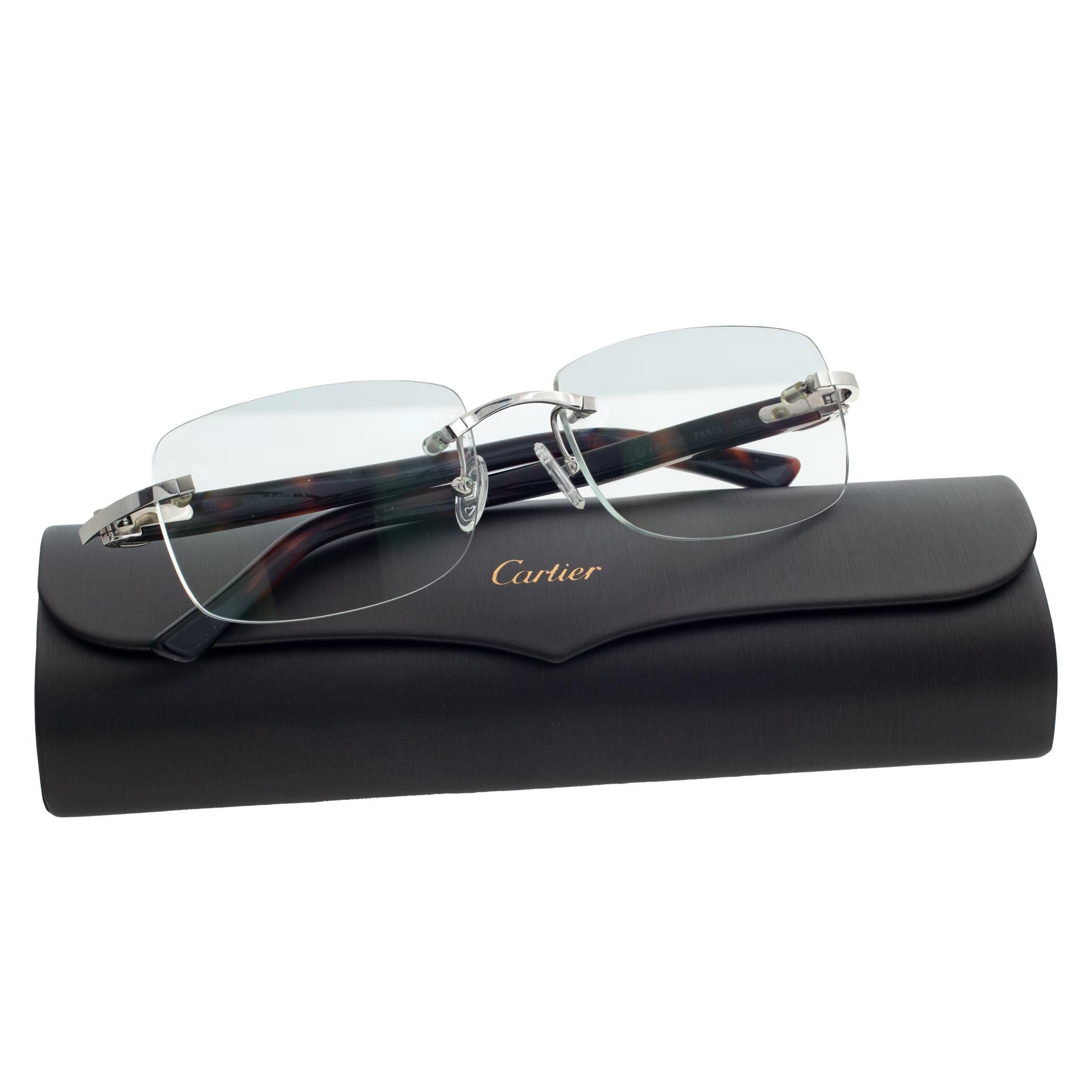 Cartier rimless eyeglasses with tortoise shell temples. Lens width 54mm, Bridge 16mm, Temple length 135mm. Comes with original box and booklet.
