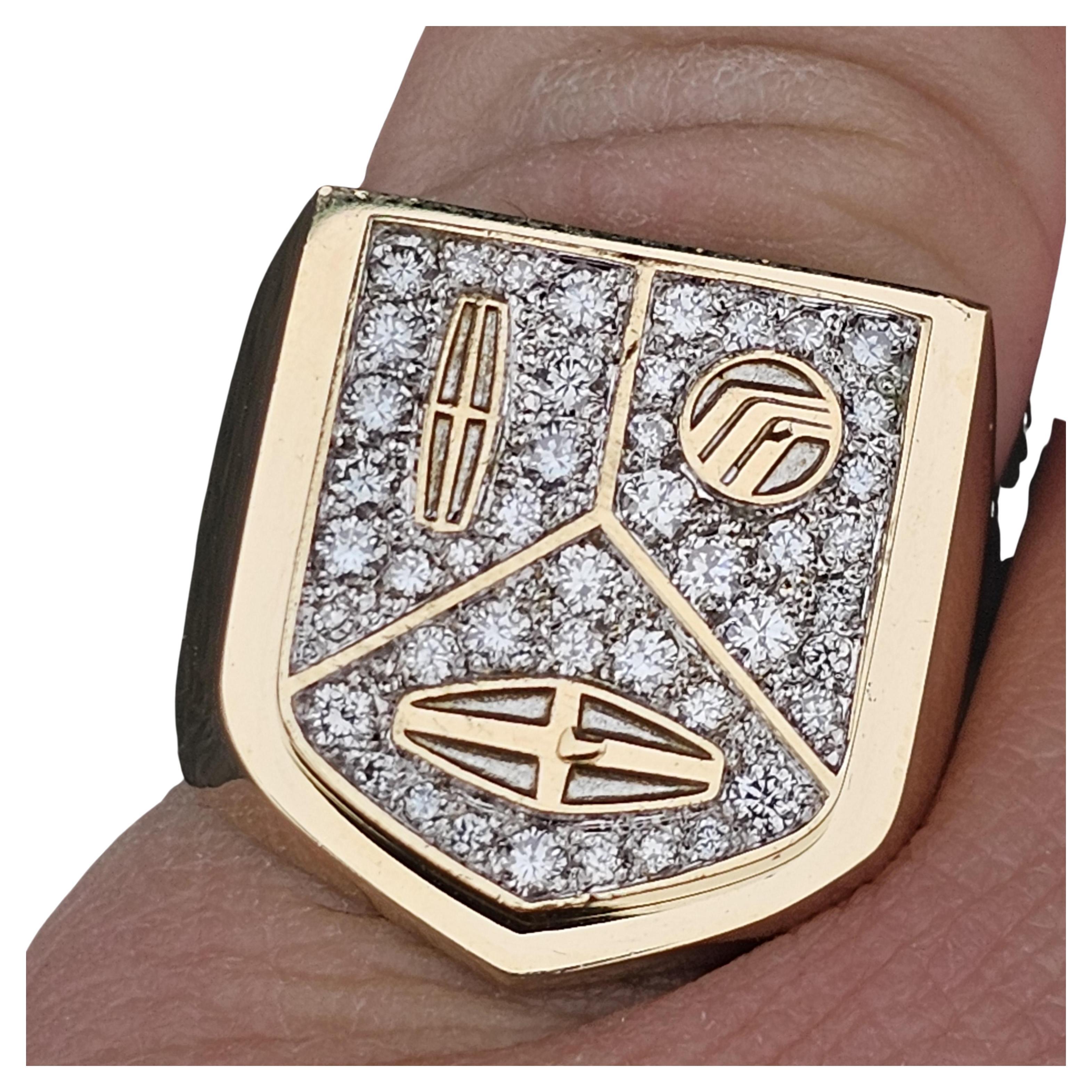 Elevate your style with this exquisite Cartier Signet Ring. Crafted from 18k yellow gold, this piece showcases a dazzling array of white diamonds. The intricate design features a shield-like face adorned with geometric car logos, adding a modern