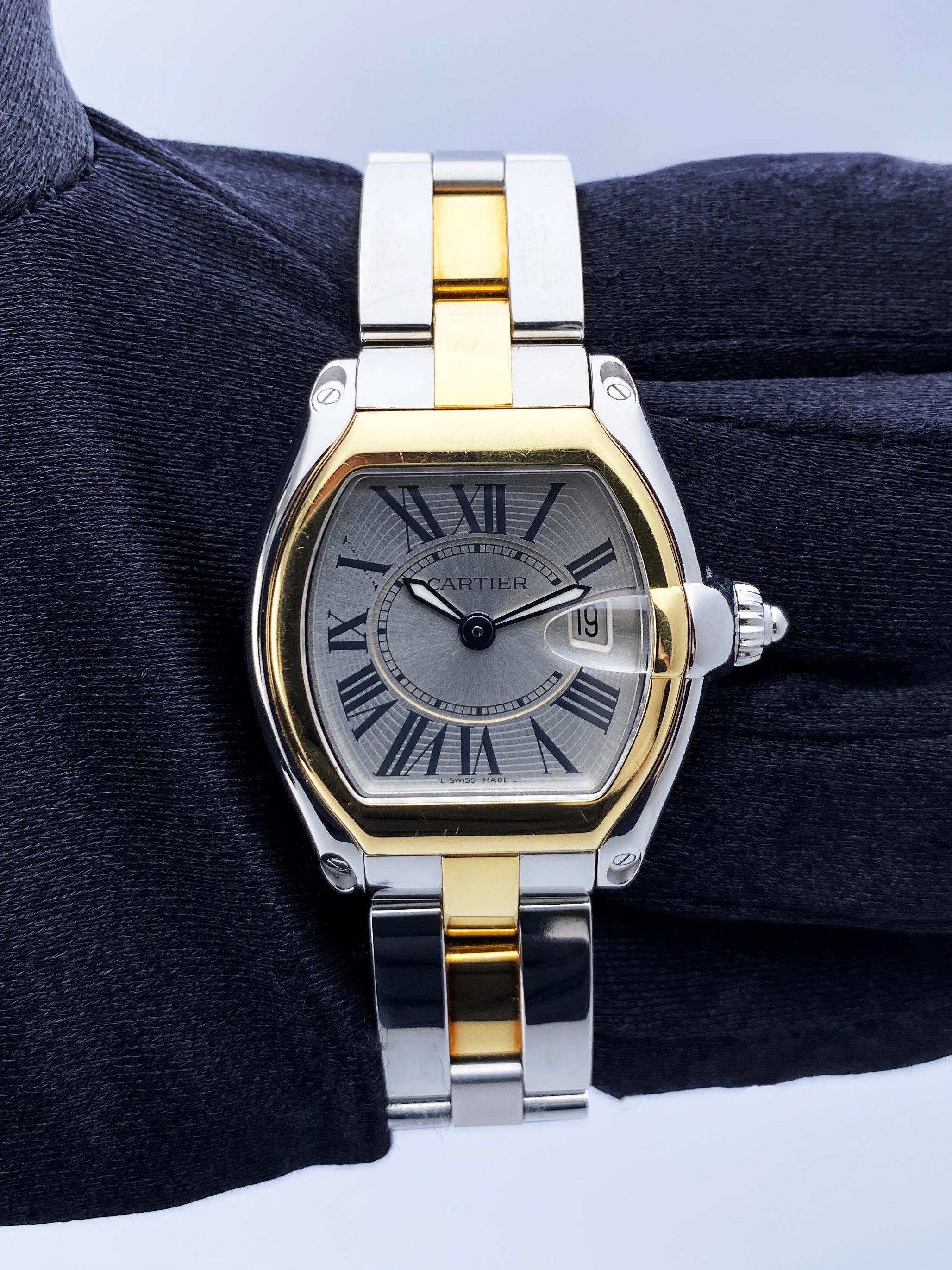 Cartier Roadster 2675 Ladies Watch. 32mm stainless steel case with 18K yellow gold smooth bezel. Silver dial with luminous hands and black Roman numeral markers. Date display at the 3 o'clock position. Minute marker on the inner dial. 18K yellow