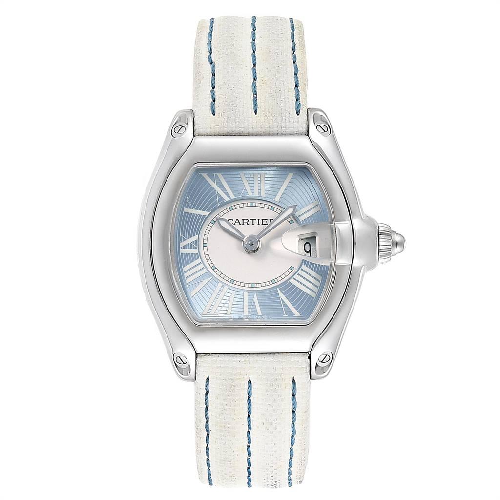 Cartier Roadster Blue Dial White Strap Steel Ladies Watch W62053V3. Swiss quartz movement. Stainless steel tonneau shaped case 36 x 30 mm. Scratch resistant sapphire crystal with Cyclops magnifying glass. Light blue dial with white roman numerals.