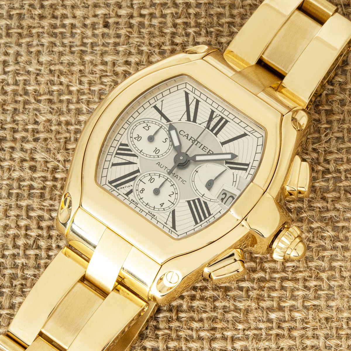A striking Cartier Roadster XL Chronograph reference W62021Y2 in solid 18k yellow gold, featuring a silver Roman numeral dial with Cartier’s secret signature at the ‘VII’. Functions include date and small seconds at 3 o’clock, 12-hour counter at 6,