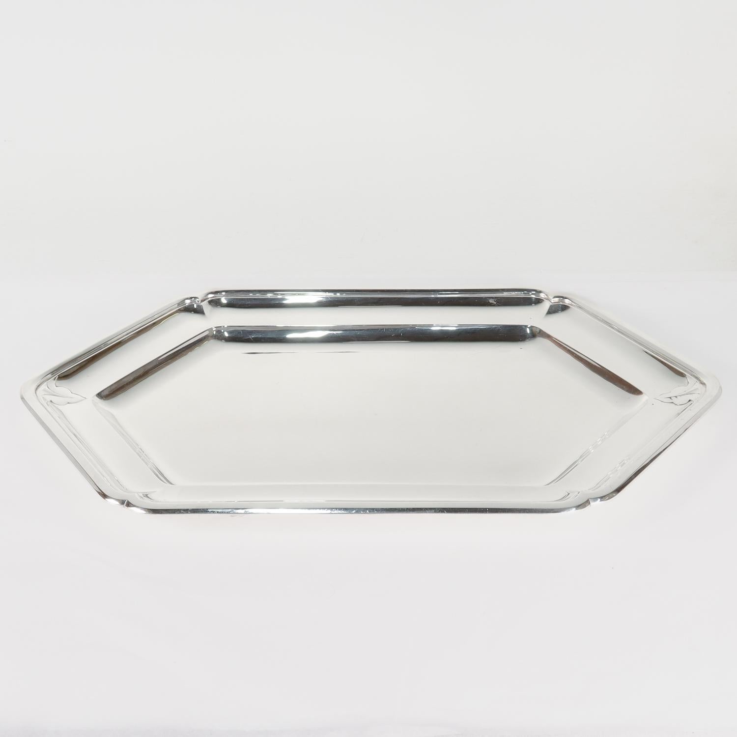 Un vassoio o piatto da portata francese Art Déco molto bello.

In argento 950. 

Di forma esagonale o a sei lati, con bordo sagomato, bordo a gradini e pozzetto poco profondo.

Decorato con una foglia stilizzata in rilievo all'estremità del