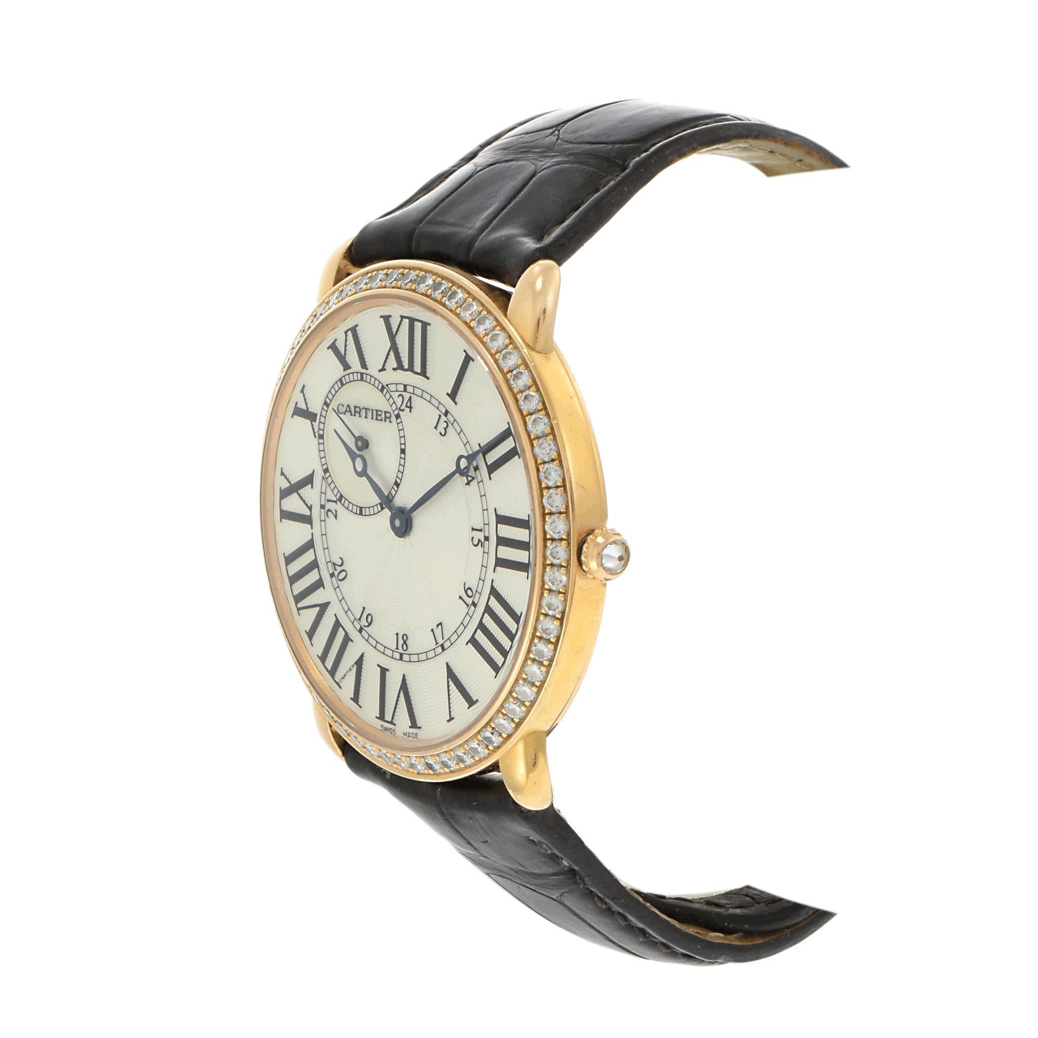 Incarnation intemporelle de l'élégance de Cartier, ce modèle Ronde Louis allie sophistication classique et détails luxueux. Réalisé en or rose 18KT, ce garde-temps de 42 mm présente un cadran guilloché argenté encadré par une lunette sertie de