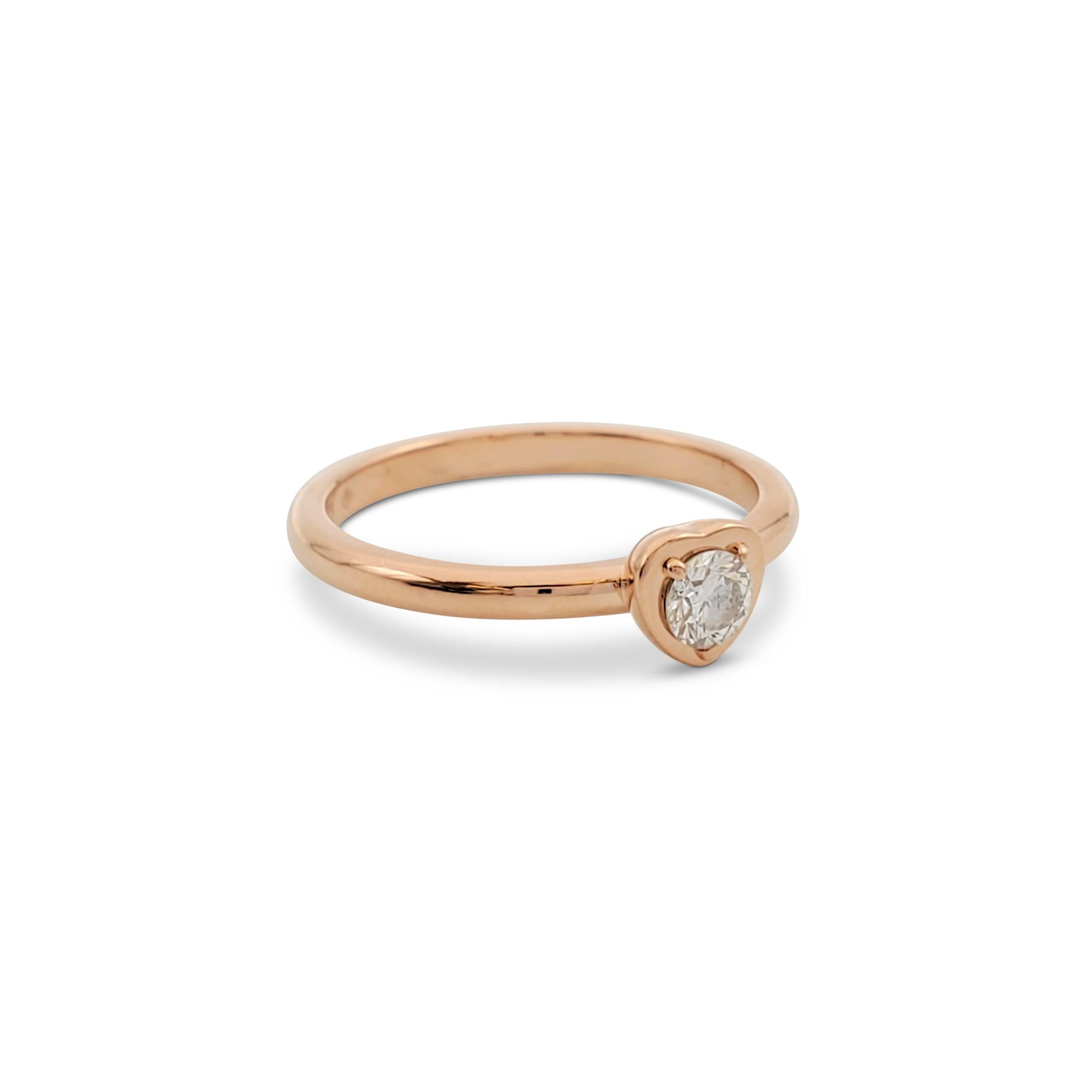 Authentic Cartier ring crafted in 18 karat rose gold centers on a single round brilliant cut diamond weighing an estimated 0.15 carats (E-F, VS) set in a heart-shaped mounting. Signed Cartier, 750, 49, with serial number and hallmark. Ring size 49