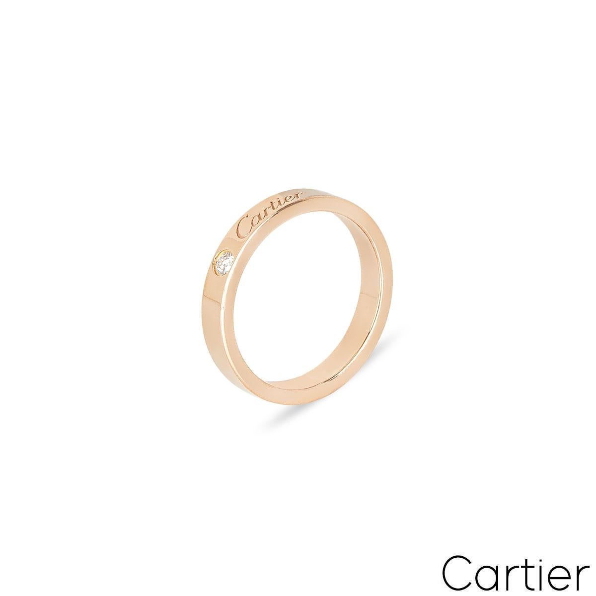 Une alliance en or rose 18 carats de la collection C de Cartier. La bague est ornée d'un diamant unique de taille brillant de 0,03ct, complété par la signature de Cartier. L'alliance a une largeur de 3 mm, une taille K.K. - EU 50 et un poids brut de