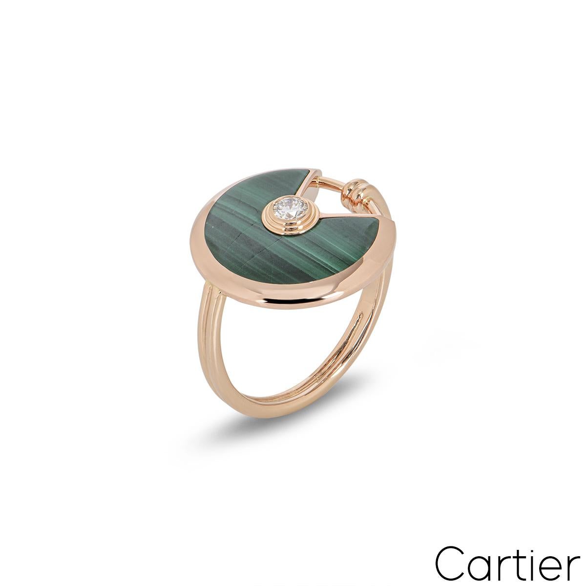 An 18k rose gold Cartier ring from the Amulette de Cartier collection. The ring comprises of a circular talisman, set with malachite and complemented by a single 0.09ct round brilliant cut diamond, in a rub over setting. The ring is a UK size M and