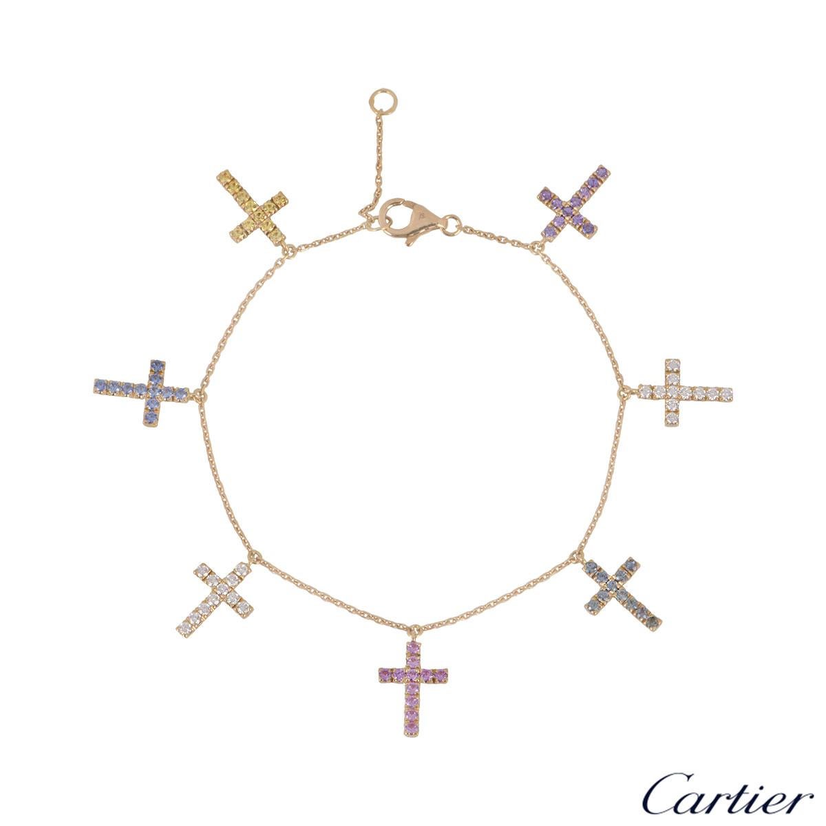 An 18k rose gold diamond and sapphire bracelet by Cartier. The bracelet is composed of 7 cross motifs set with diamonds and pink, yellow, blue, purple, green sapphires. There are 22 diamonds with an approximate weight of 0.31ct and the 55 sapphires