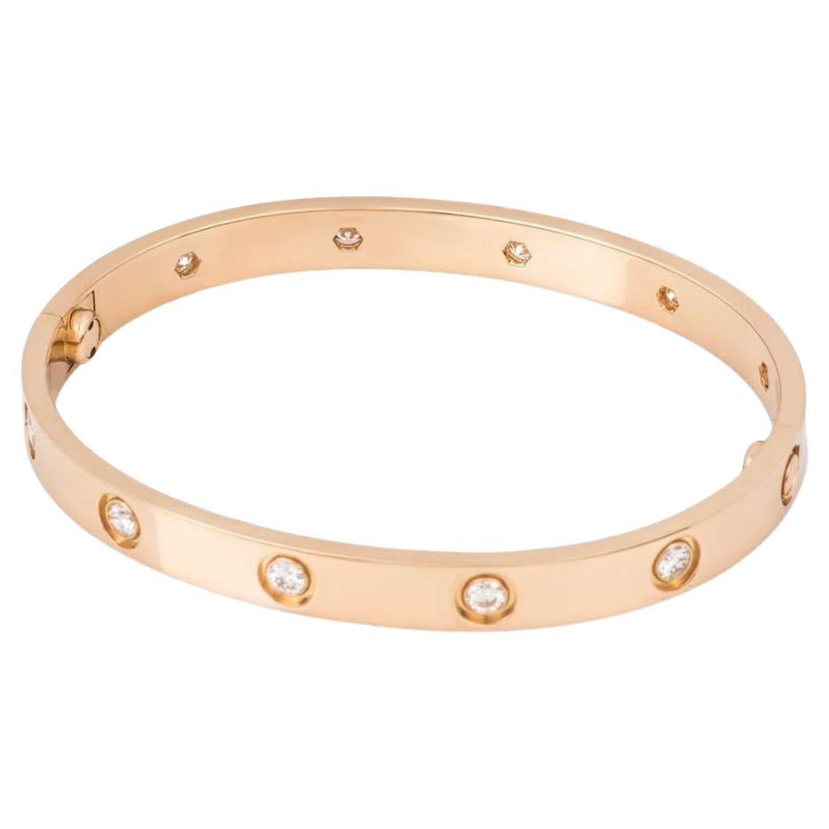 An 18k rose gold full diamond Love bracelet by Cartier. The bracelet is set with 10 round brilliant cut diamonds circulating the outer edge throughout totalling 0.96ct. The bracelet is a size 20 and features the new style screw fitting and has a