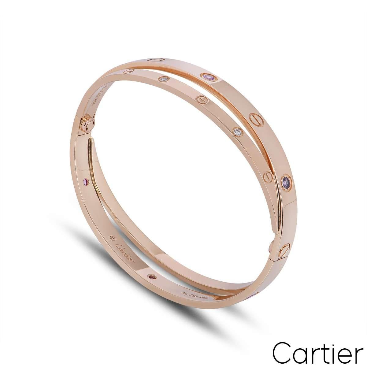 An iconic 18k rose gold half diamond and pink sapphire double Cartier bracelet from the Love collection. The double bangle features the iconic screw motif alternating with 6 round brilliant cut diamonds and 6 pink sapphires displayed around the