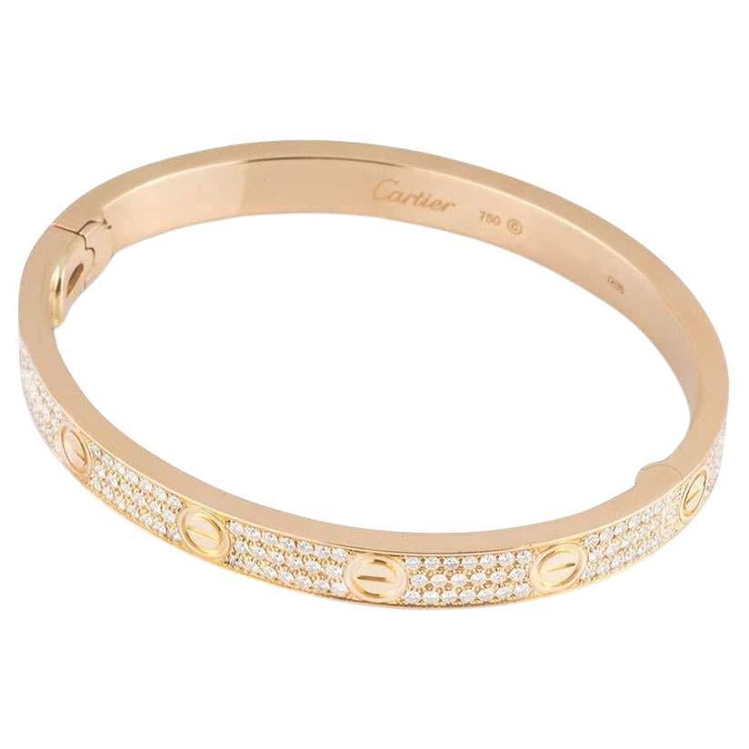 An 18k rose gold diamond bracelet by Cartier, from their Love collection. The bracelet has 12 of the iconic screw motifs on the outer edge with 204 round brilliant cut diamonds pave set between the screws with an approximate total weight of 1.99ct.