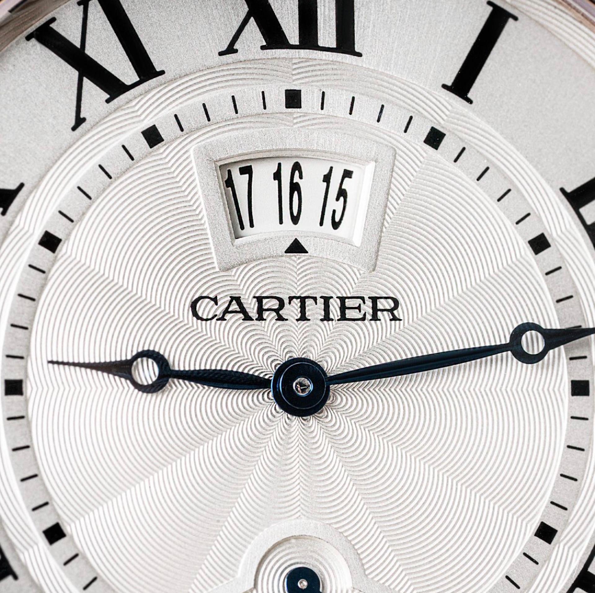 Une montre-bracelet Cartier Rotonde en or rose. Dotée d'un cadran argenté guilloché avec chiffres romains, d'un affichage de la date, d'un indicateur de réserve de marche et d'aiguilles en acier bleui. La montre est équipée d'un verre saphir, d'un