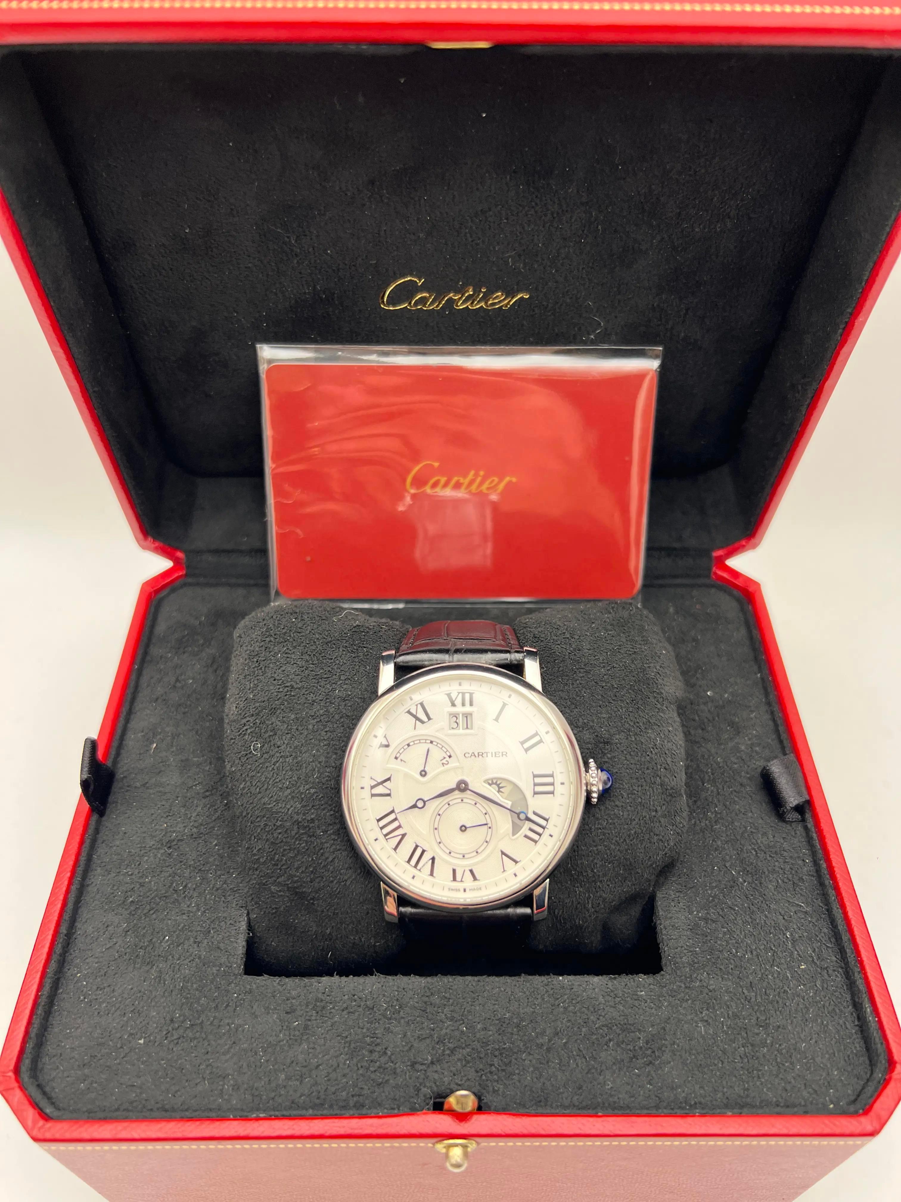 The Cartier Rotonde de Cartier, reference W1556368, is a sophisticated timepiece that combines classic design with practical complications. Housed in a 42mm stainless steel case, it features a silvered guilloché dial adorned with black Roman