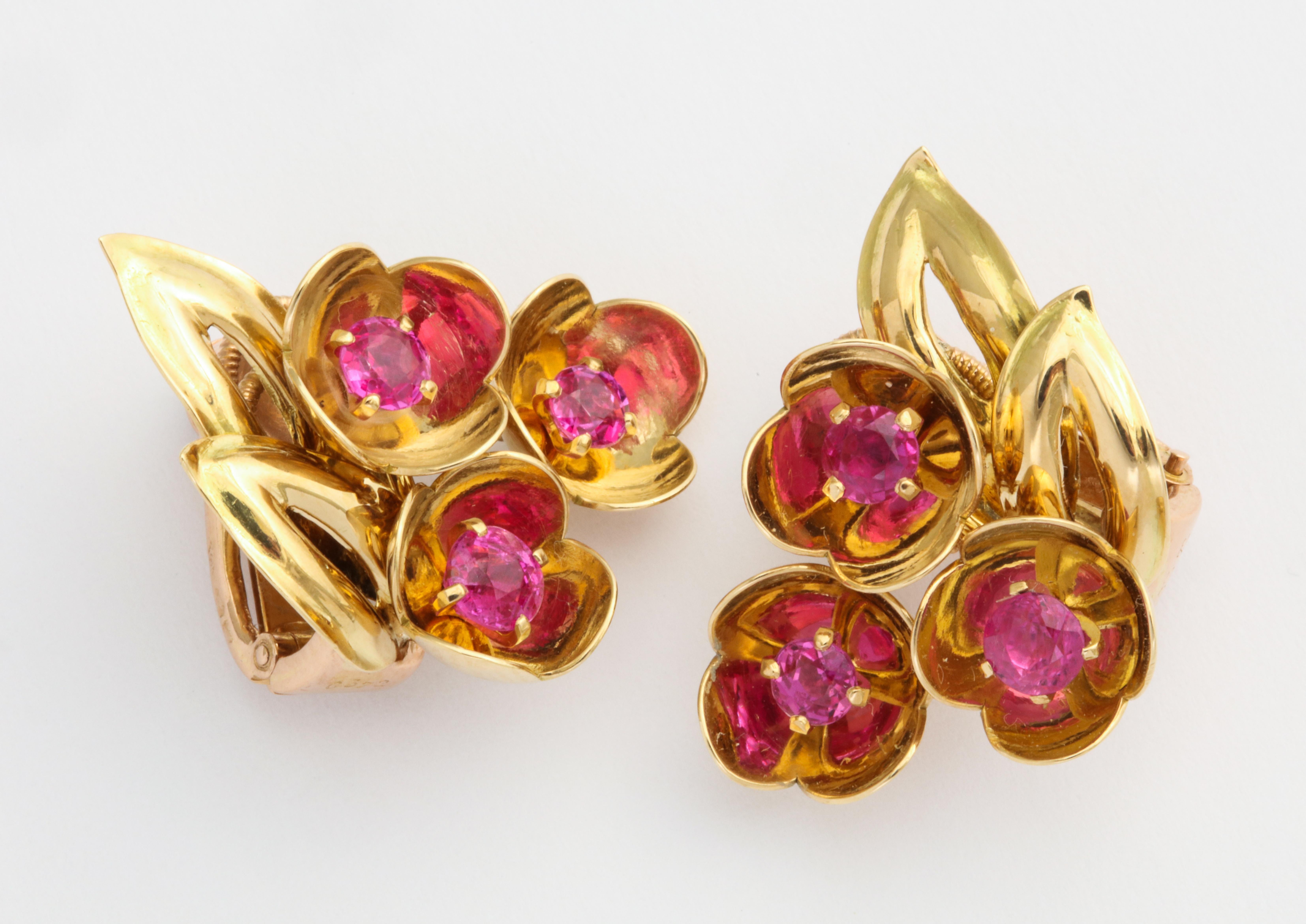 Stunningly simple, this retro era Cartier ear clip will be your go-to daytime earring for all seasons.  The rubies are a vibrant hot pinkish red faceted stone set in a gold mirror effect cup. You will live in these!
