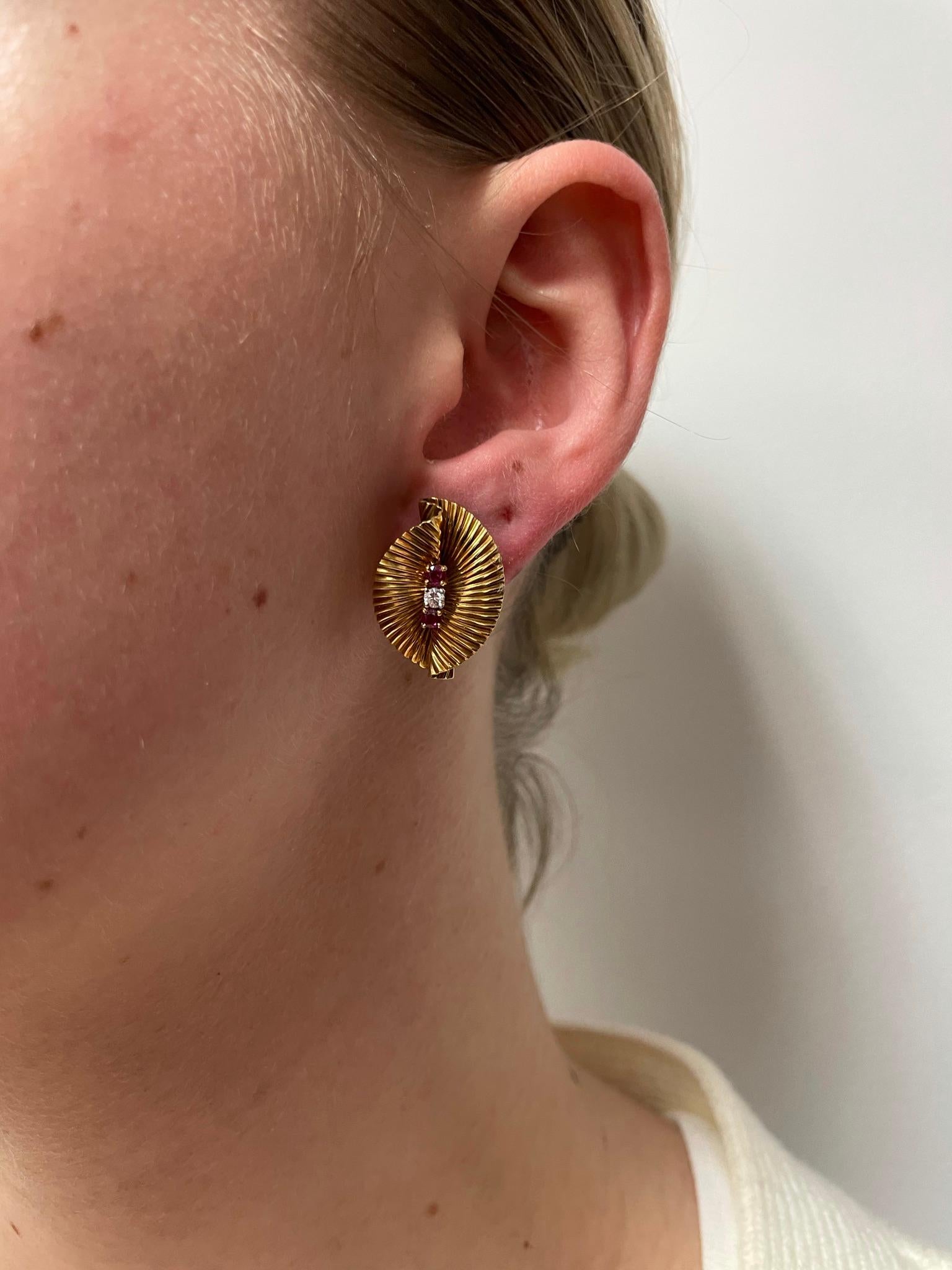 Trendy earrings with twisted 18K Yellow Gold, each vertically prong-set with two rubies and one diamond. Length: 1”. Circa 1950s, Signed Cartier.