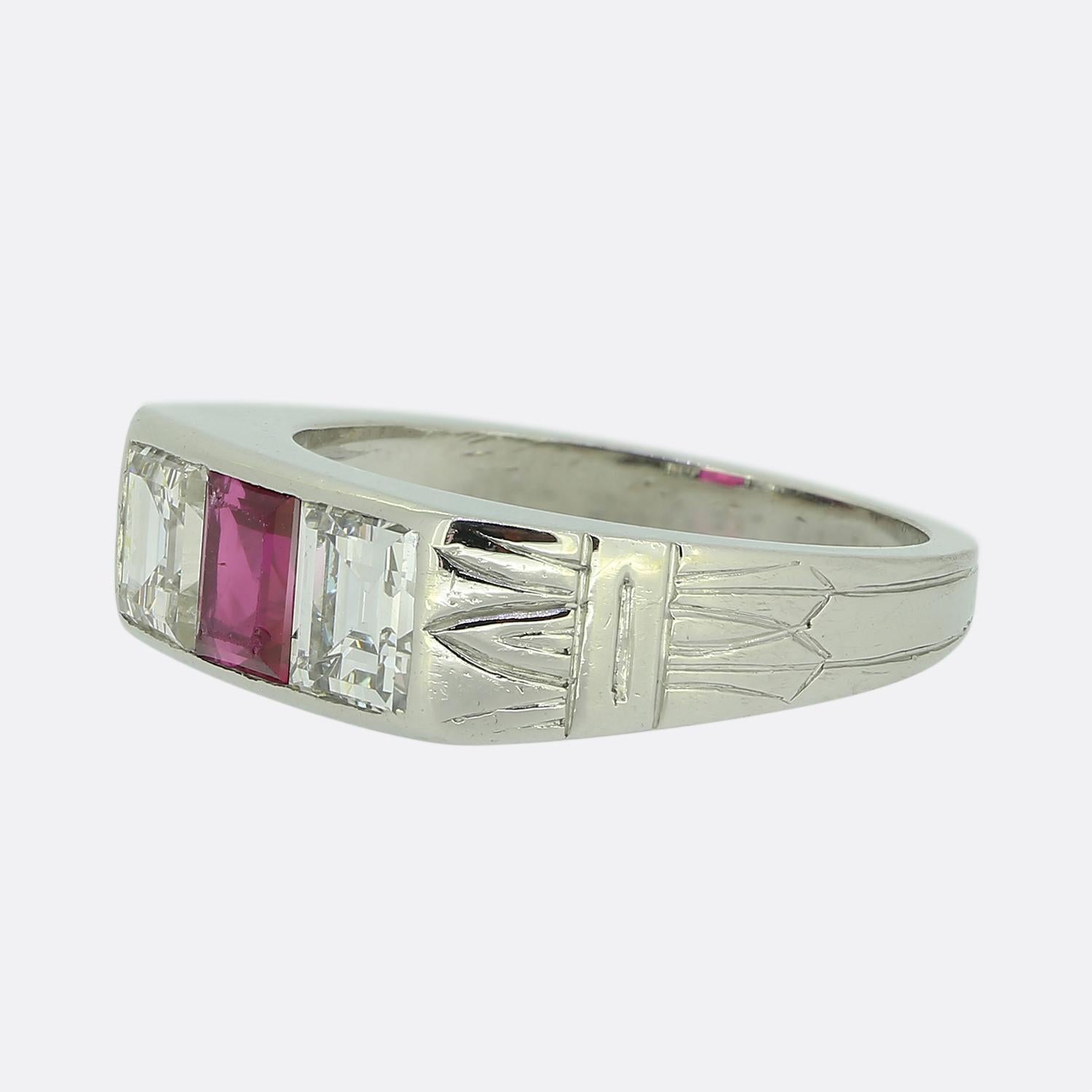 Here we have a smart and sophisticated three-stone ring from the world renowned luxury jewellery house of Cartier. This piece has been crafted from platinum and showcases a square-cut ruby, radiating a lively pinky red colour at the centre of the