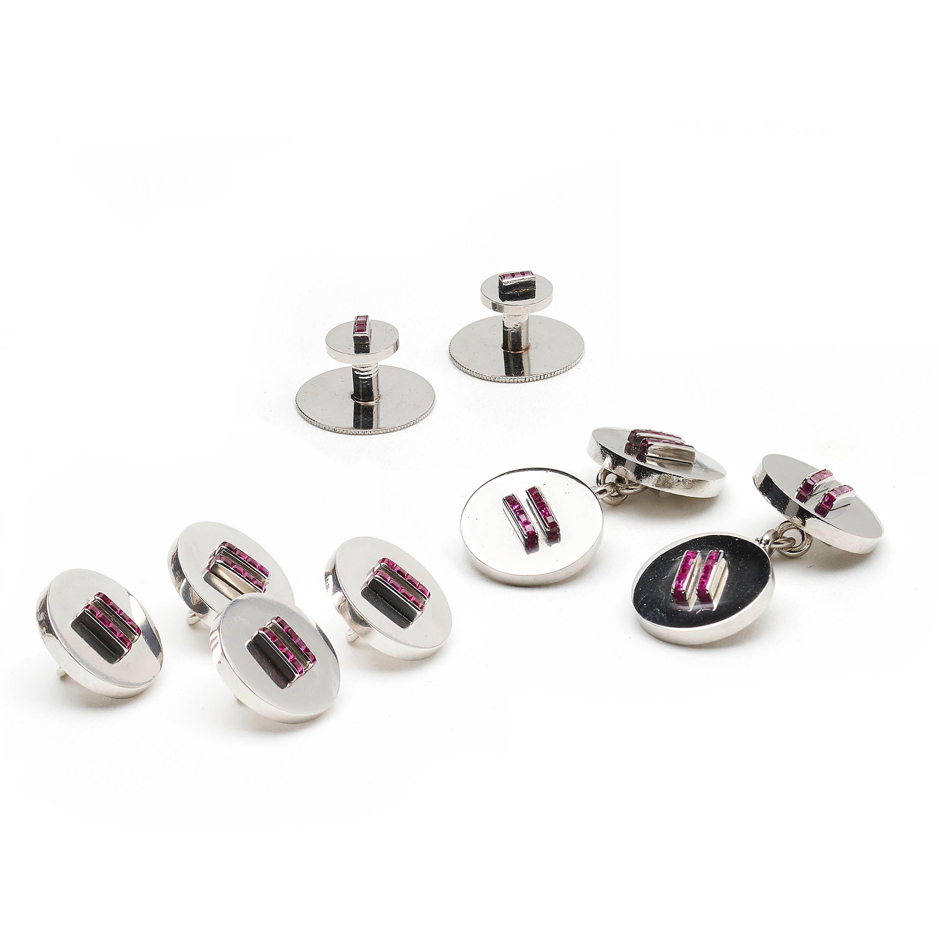 Conjunto de vestir Cartier de rubíes y platino, compuesto por un par de gemelos, cuatro botones y dos tachuelas, los botones y las cabezas de los gemelos están engastados cada uno con dos filas de ocho rubíes talla calibre, las tachuelas del cuello