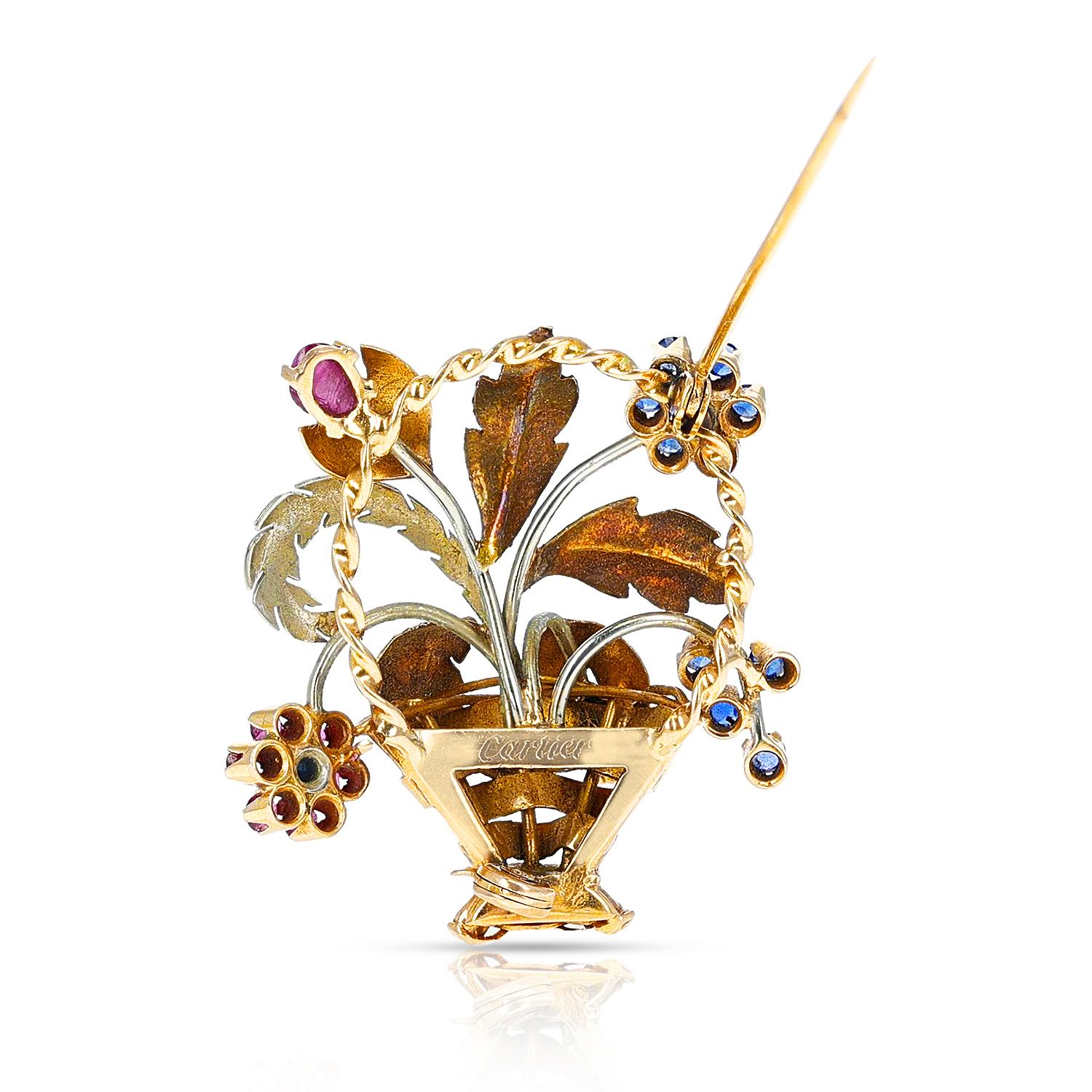 A Cartier Ruby and Sapphire Flower Bouquet Brooch made in 18 Karat Two Tone Gold. The brooch has carvings and cut stones, and also carvings. The total weight is 12.53 grams. Length: 1 5/8