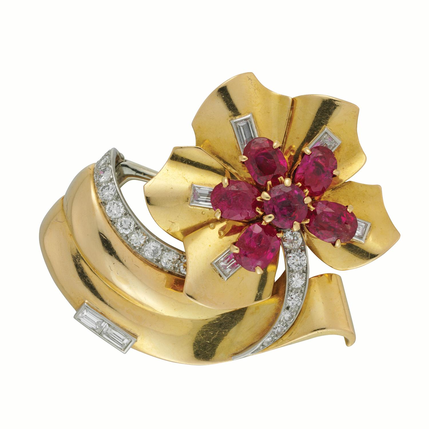 A 1950's Cartier ruby, diamond and gold stylised flower brooch, with a cluster of six oval faceted Burmese rubies weighing 4.86 carats in total, set to the centre of a gold flower with one baguette-cut diamond weighing approximately 0.10 carats