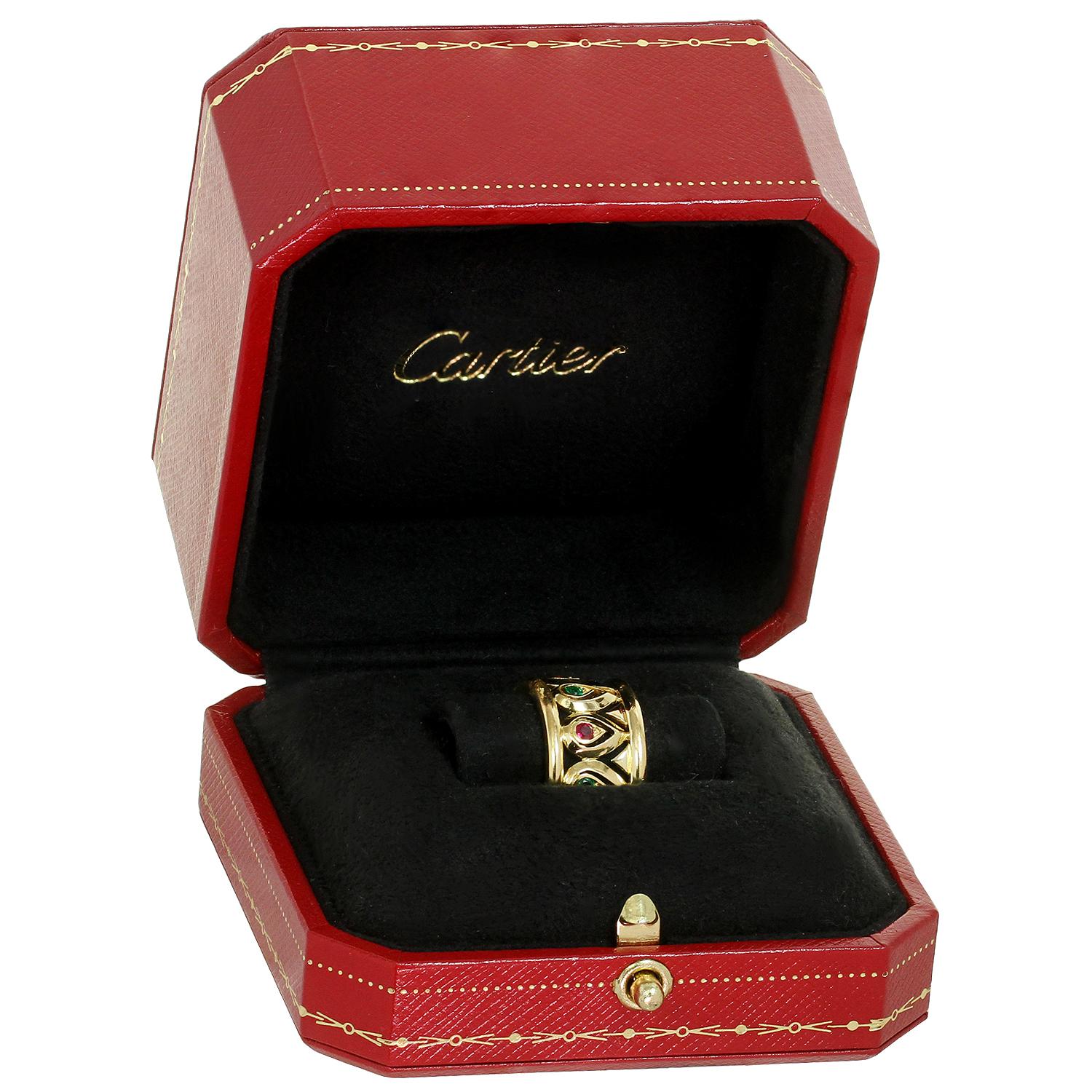 Dieser seltene Cartier-Ring hat ein elegantes, durchbrochenes, breites Band aus 18 Karat Gelbgold und ist mit runden roten Rubinen und grünen Smaragden besetzt. Hergestellt in Frankreich in den 1990er Jahren. Abmessungen: 0.47