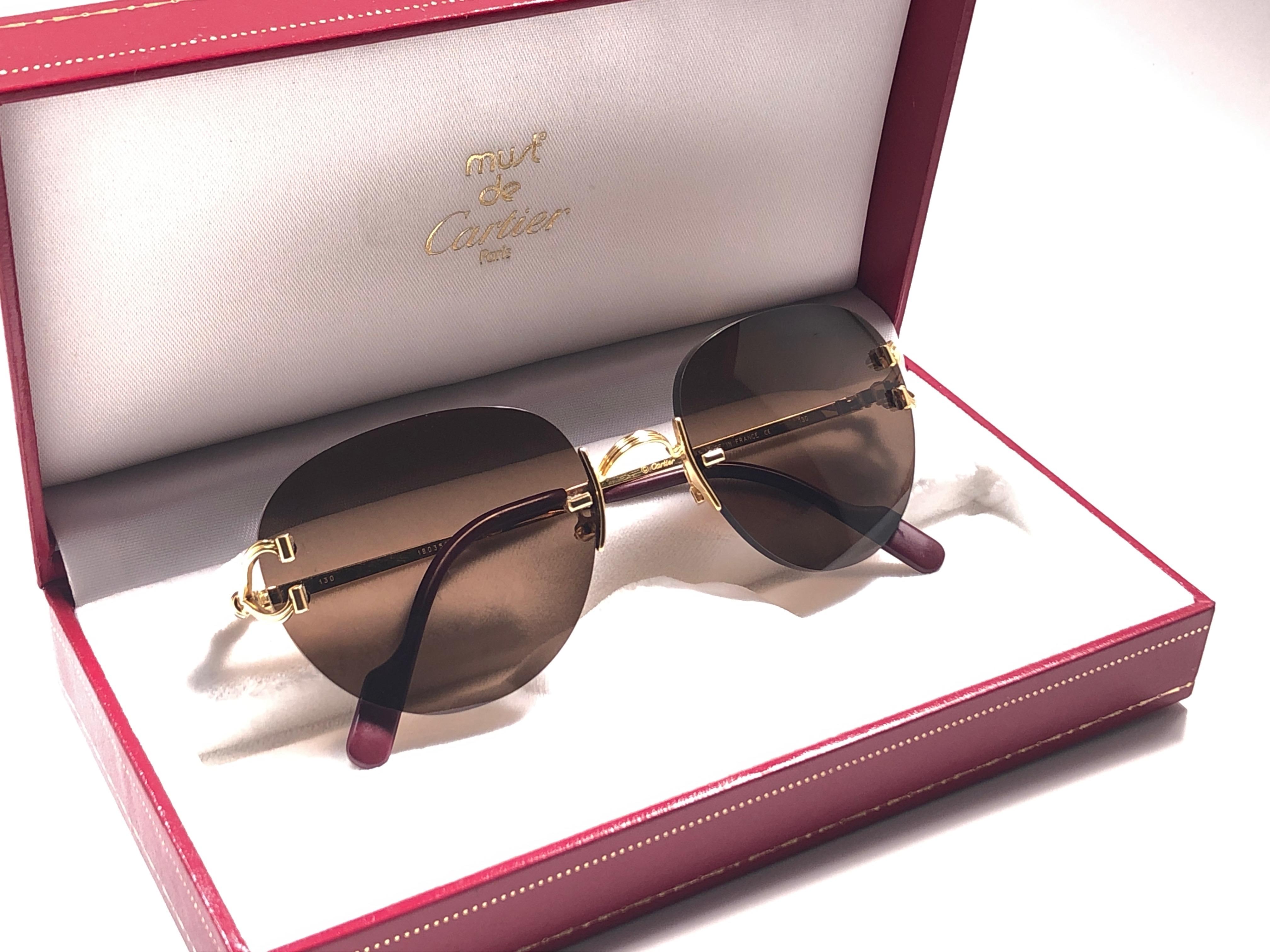New Cartier Salisbury unique rimless special edition sunglasses with solid brown (uv protection) lenses.  Frame with the front and sides in special edition gold. All hallmarks. Cartier gold signs on the ear paddles.  These are like a pair of jewels