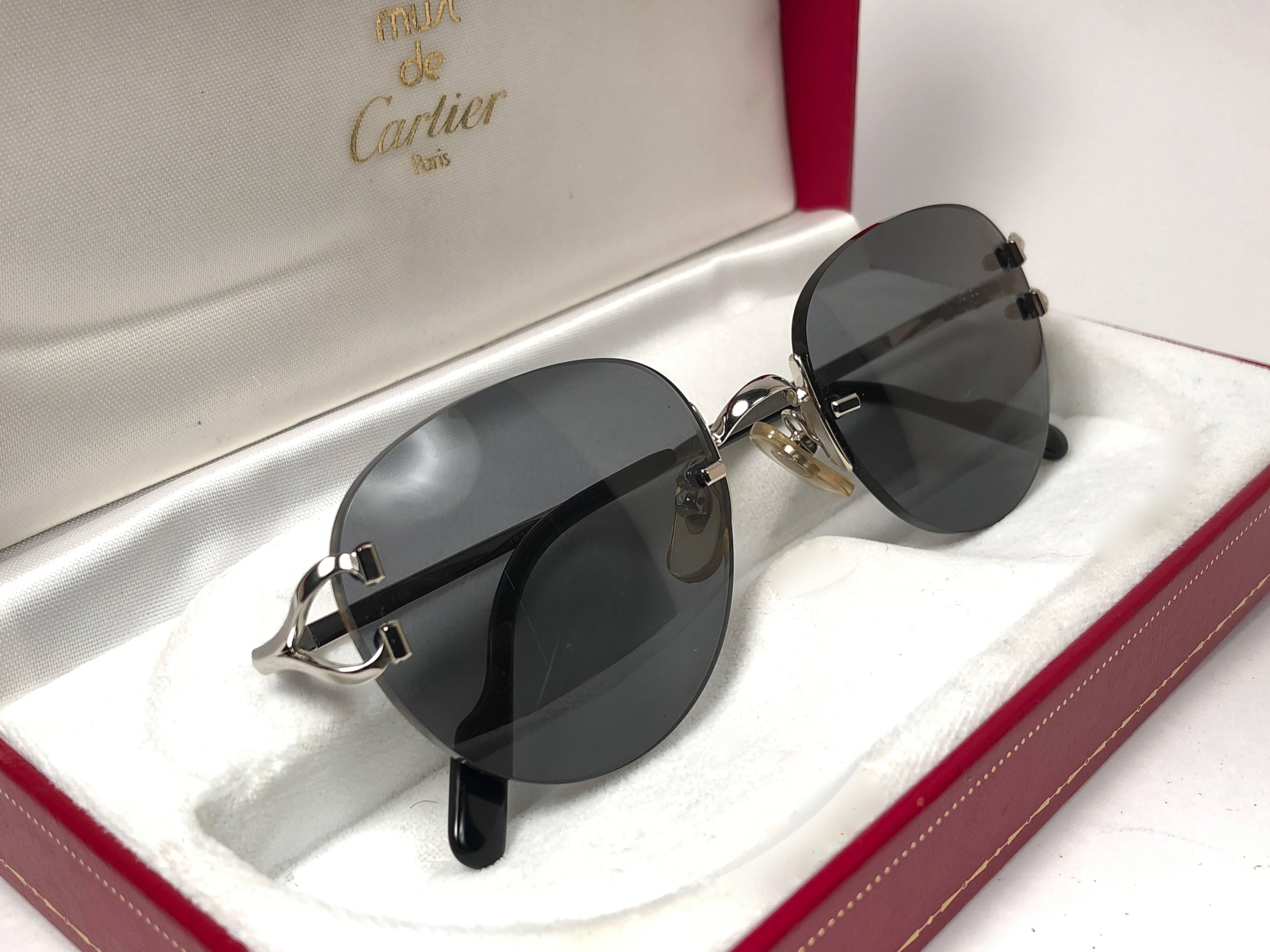 New Cartier Salisbury unique rimless sunglasses with Grey G15 (uv protection) lenses.  Frame with the front and sides in platine. All hallmarks. Cartier gold signs on the ear paddles.  These are like a pair of jewels on your nose.  Beautiful design