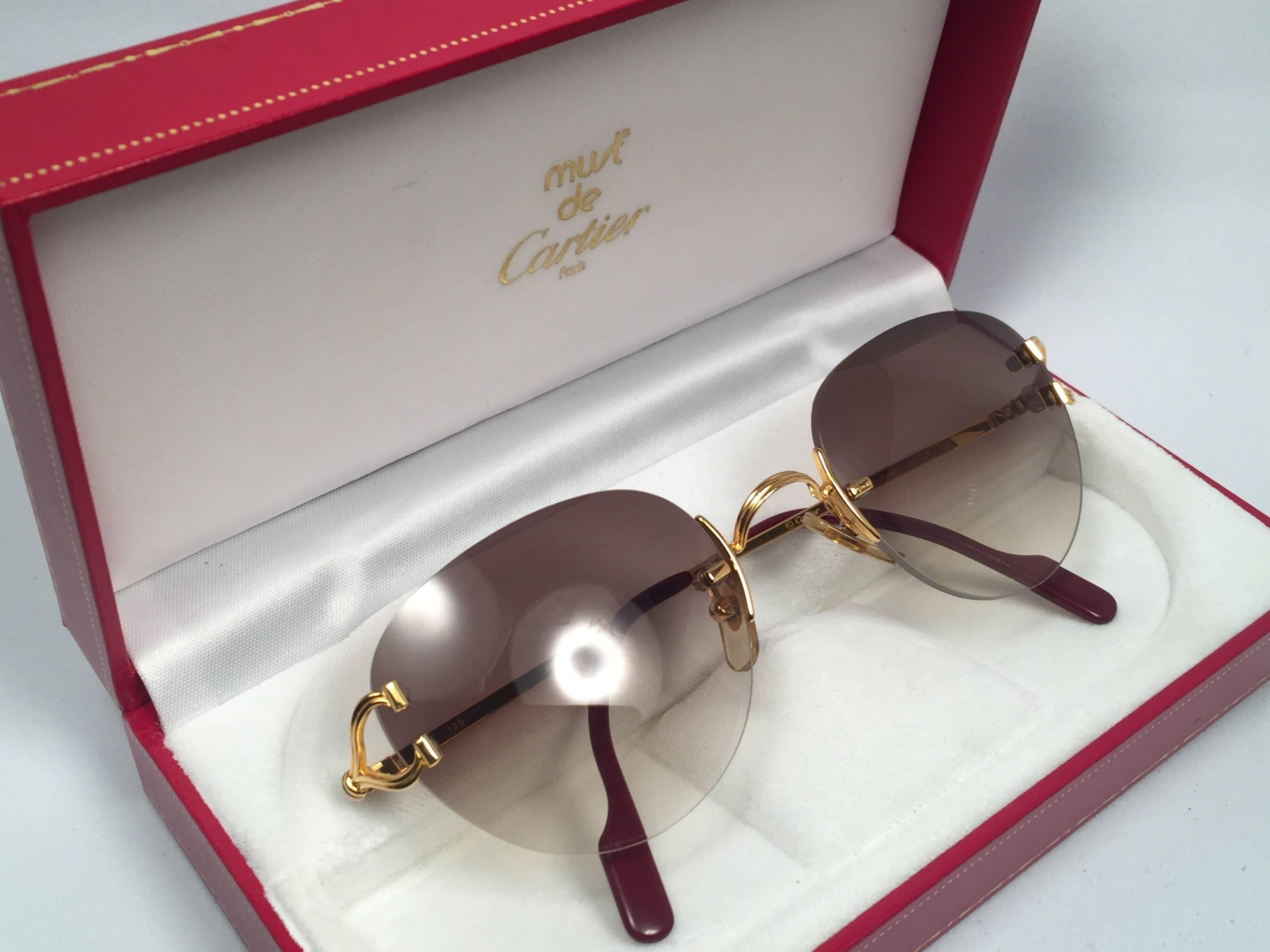 New Cartier Salisbury unique rimless special edition sunglasses with brown gradient (uv protection) lenses. Frame with the front and sides in gold. All hallmarks. Cartier gold signs on the ear paddles. These are like a pair of jewels on your nose.