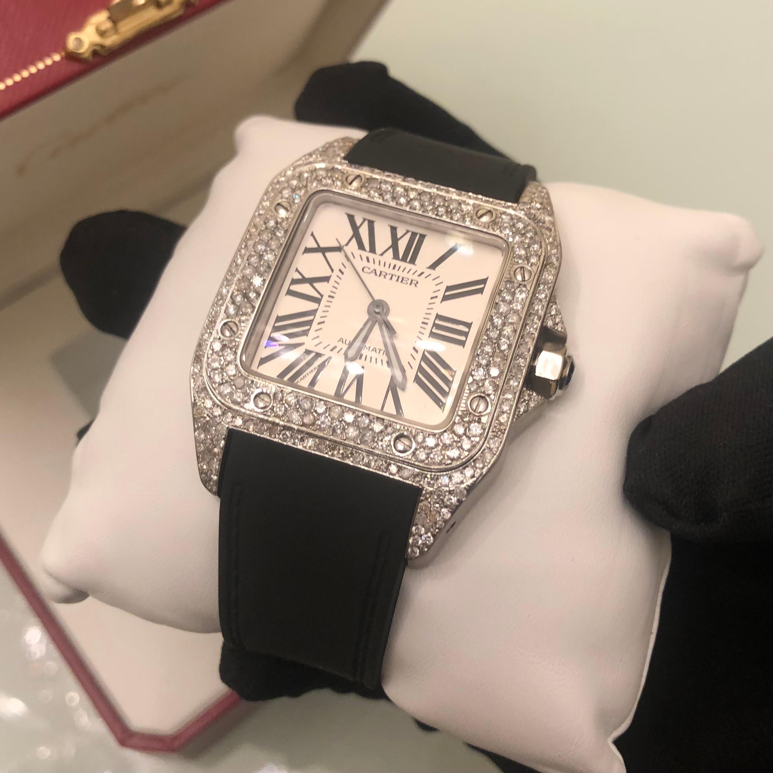 Custom Cartier Santos 100XL complete with box and booklet papers. 

Cartier Santos 100XL is customized hand set with approx. 8 carats of natural earth mined diamonds in the bezel, case lugs, and clasp. The diamonds shine beautifully in the light.