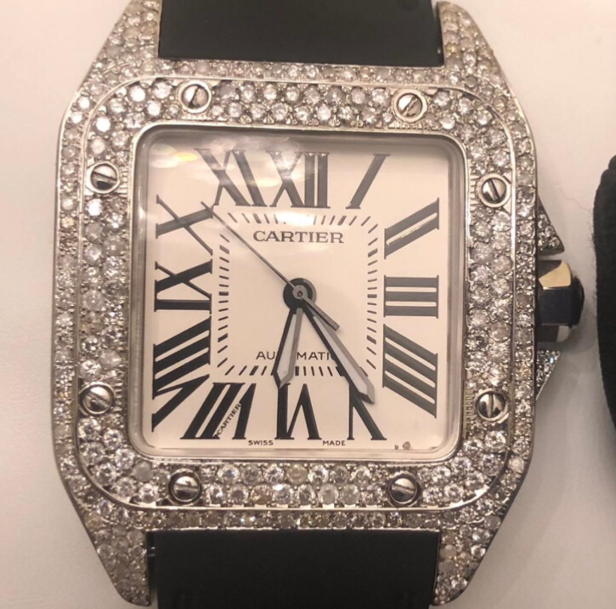Custom Cartier Santos 100XL complete with box and booklet papers.

Cartier Santos 100XL is customized hand set with approx. 8 carats of natural earth mined diamonds in the bezel, case lugs, and clasp. The diamonds shine beautifully in the