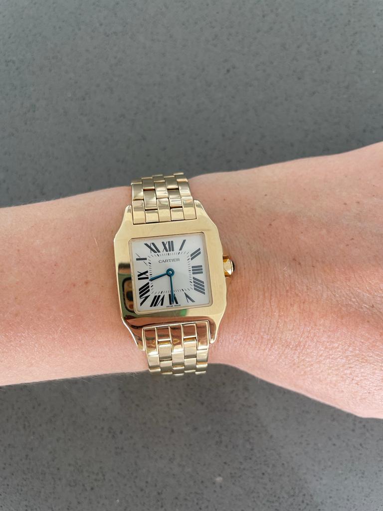 Cartier Santos Demoiselle 18k Yellow Gold 

Midsize Watch- Quartz. 

18k yellow gold case (26mm x 38mm).

 Ivory colored dial with black Roman numerals. 

18k yellow gold Cartier bracelet with deployant clasp. 

Worn a dozen times, fantastic