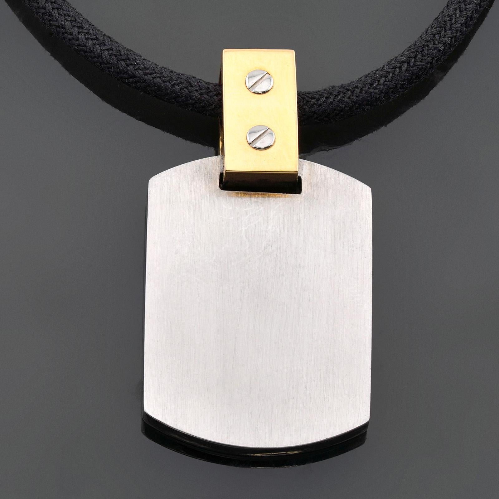 This classic Cartier Santos pendant is crafted in 18k yellow gold and stainless steel and completed with a black cord necklace. Made in France circa 2020s. Measurements: 0.82