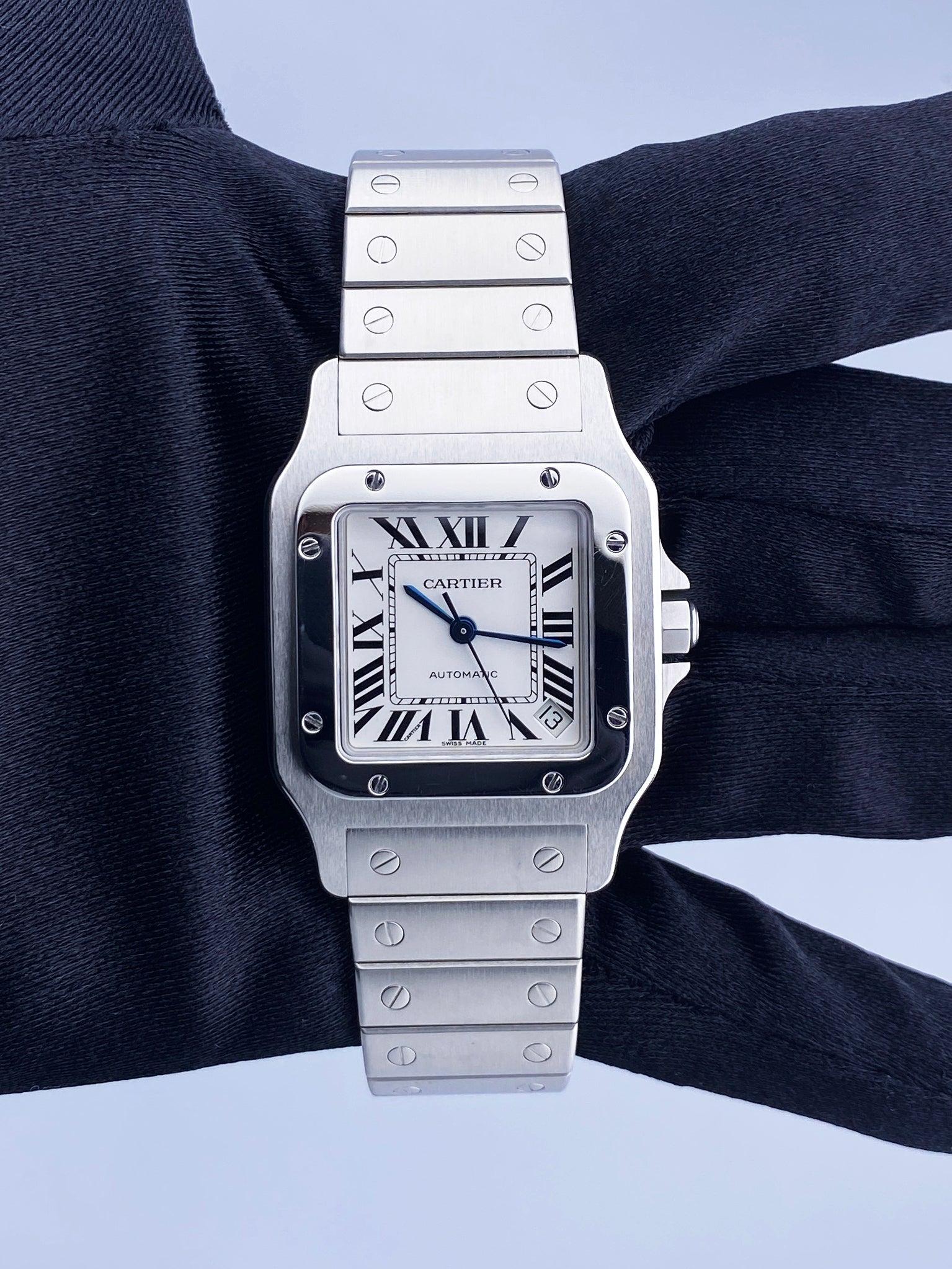 Cartier Santos 2823 Mens Watch. 32mm stainless steel case with stainless steel fixed bezel. Silver dial with blue steel hands Black Roman numeral hour markers. Minute markers around an inner dial. Date display between 4 and 5 o'clock position.
