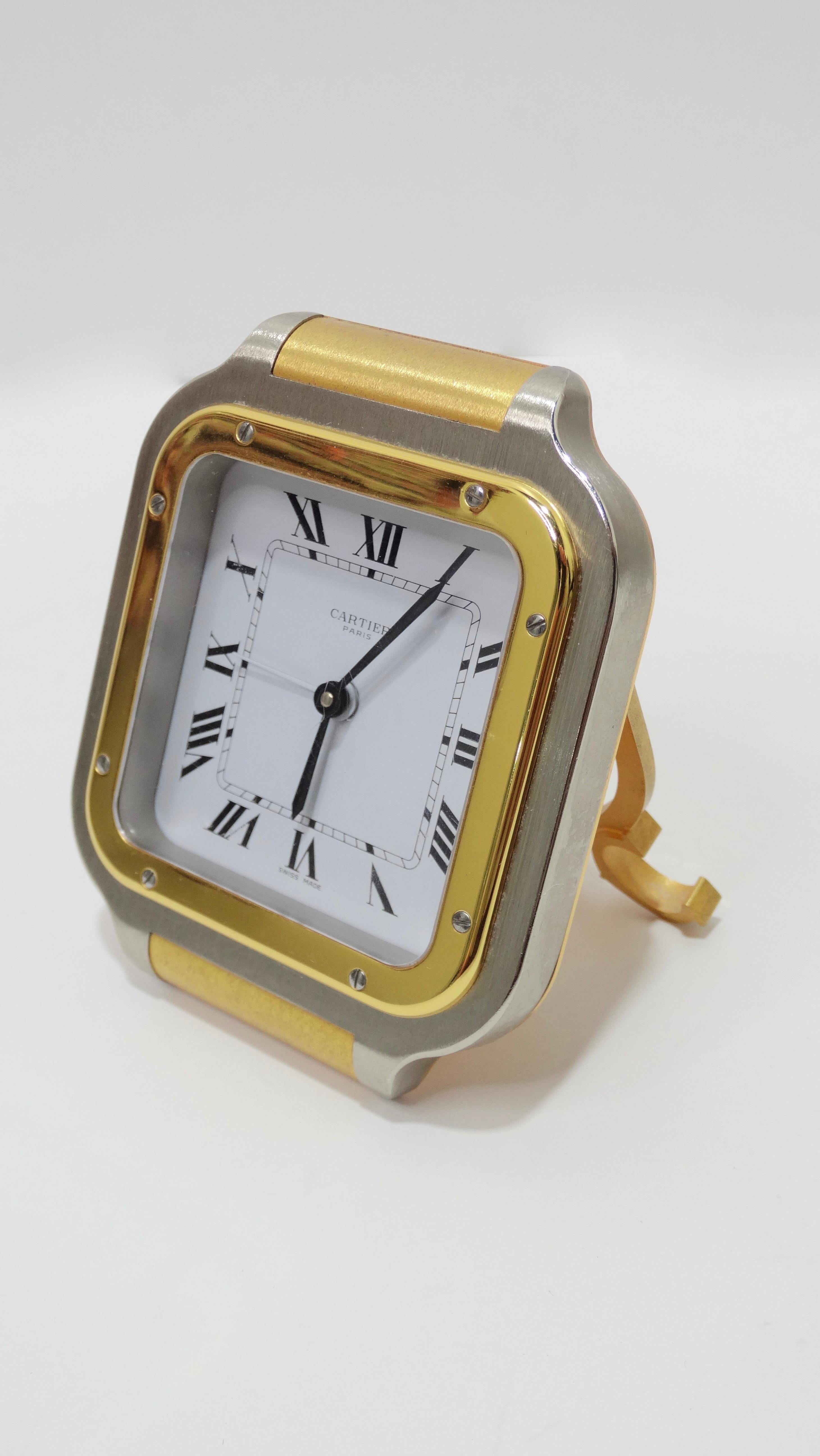 Get woken up in style with this amazing Cartier alarm clock! Circa early 1990s, this Swiss made alarm clock is modeled after the famous Cartier Santos wristwatch and features a kickstand, contrasting silver/gold finish, roman numerals and Quartz