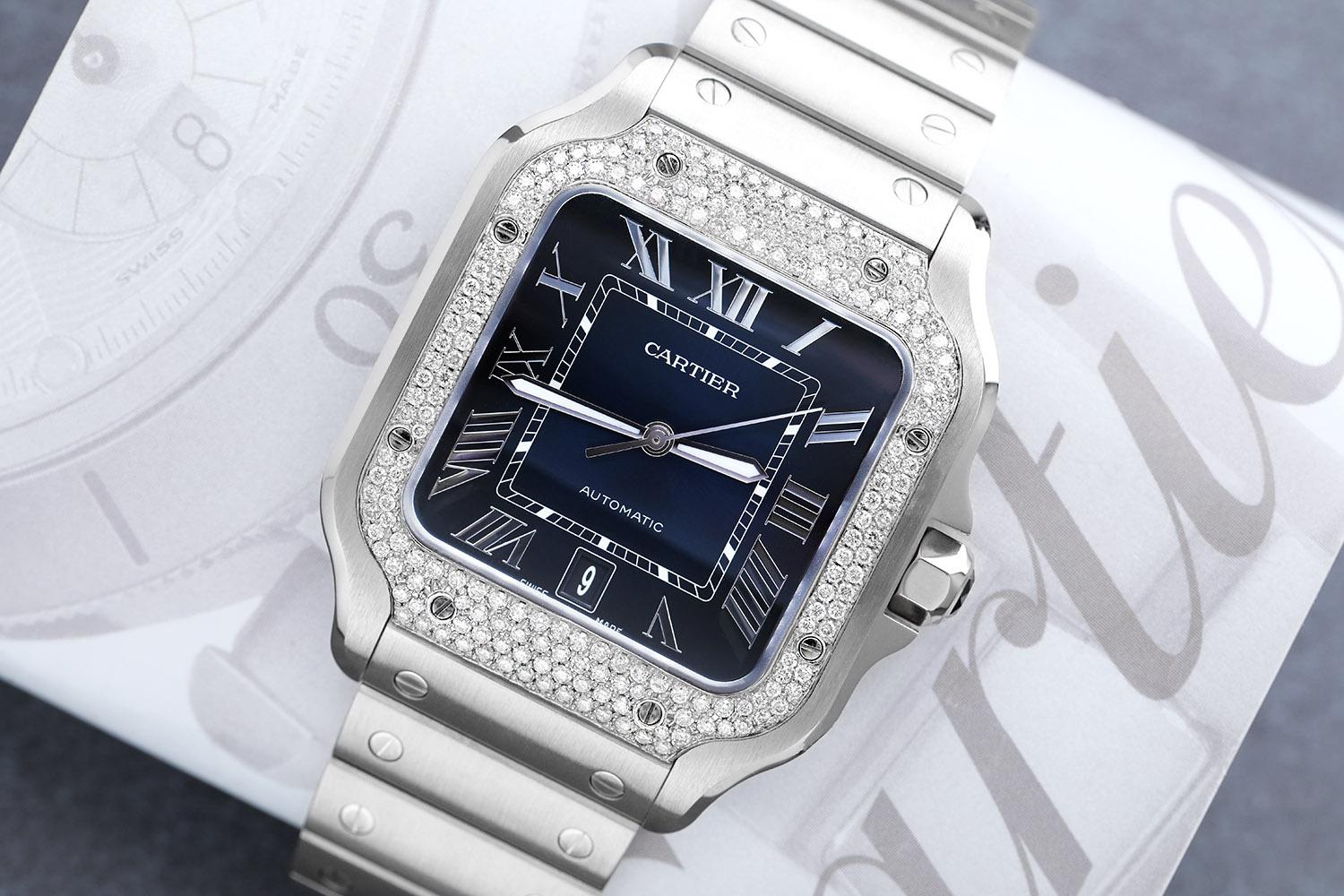 Cartier Santos Large Stainless Steel Watch with Custom Diamond Bezel Factory Blue Roman Numeral Dial
WATCH COMES WITH AN ADDITIONAL BLUE LEATHER STRAP! Mechanical movement with automatic winding, caliber 1847 MC. Steel case, 7-sided crown set with a