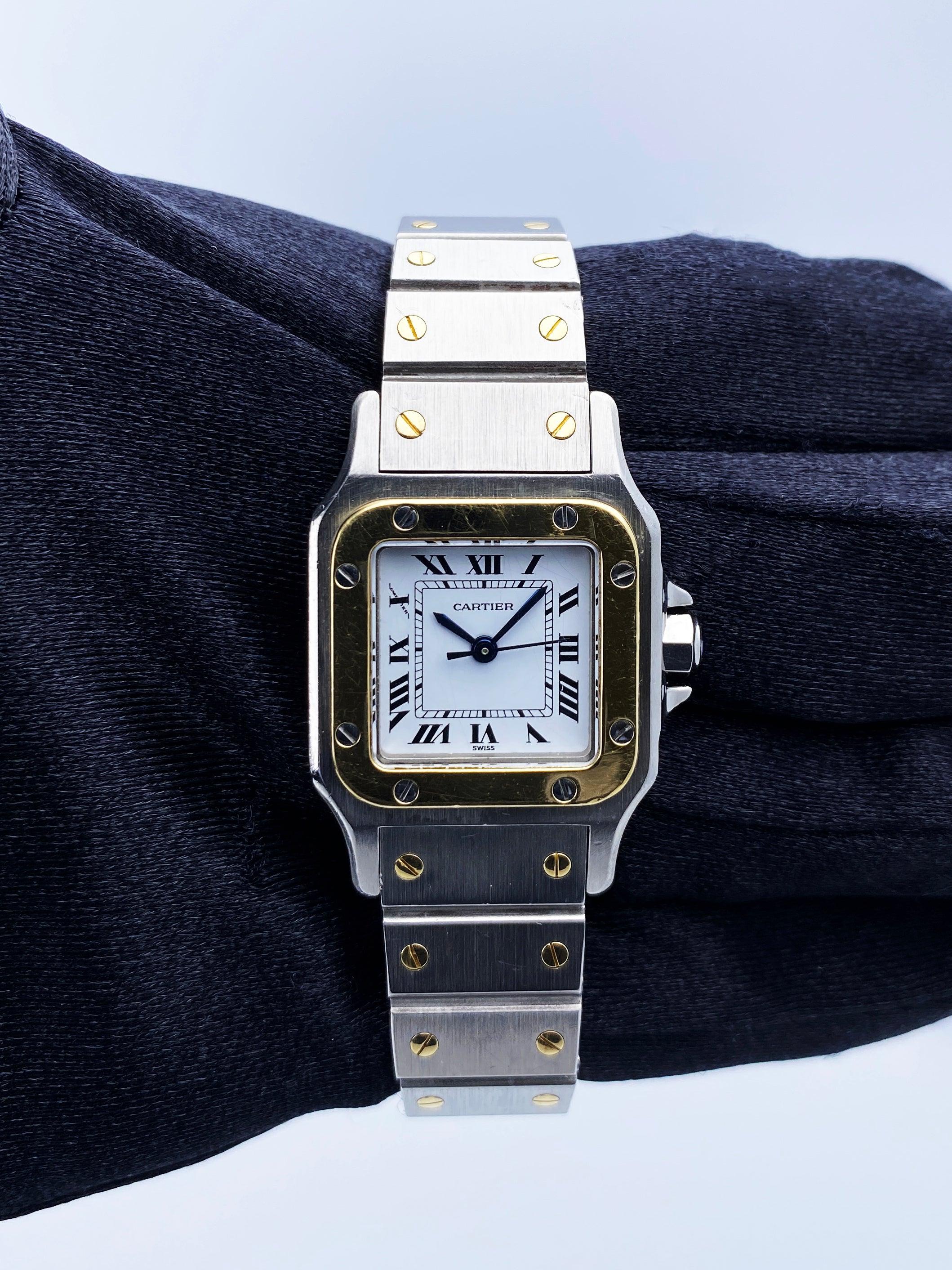 Cartier Santos Galbee 0902 Ladies Watch. 24mm stainless steel case. 18K yellow gold fixed bezel. White dial with blue hands and Roman numeral hour marker. Minute marker on the inner dial. 18K yellow gold and stainless steel bracelet with fold over