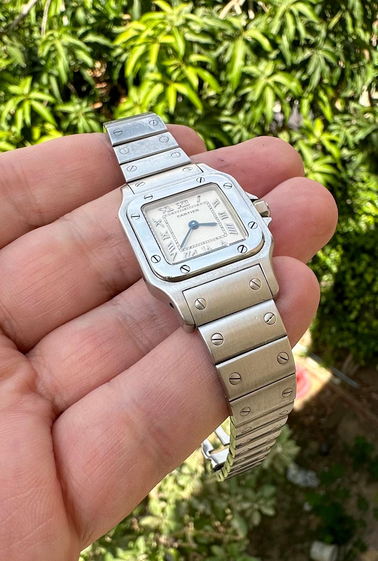 Brand: Cartier

Model: Santos Galbée

Reference Number: 1565

Country Of Manufacture: Switzerland

Movement: Quartz

Case Material: Stainless steel

Measurements : Case width: 24 mm. (without crown) x 35 mm

Band Type : Gold Cartier Buckle Mark &