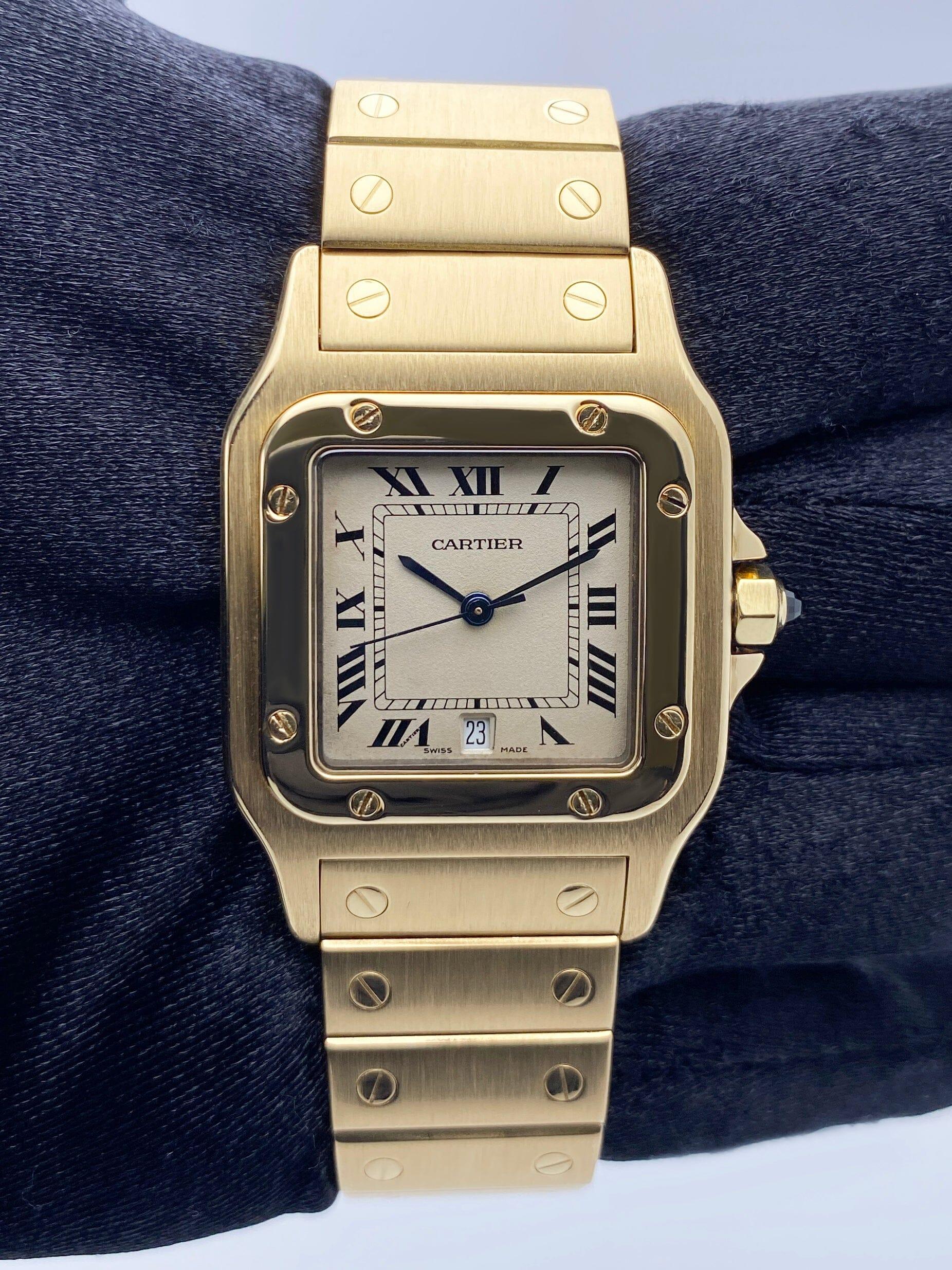 Cartier Santos Galbee Watch. 29mm 18K yellow gold case. 18K yellow gold bezel. Off-White¬†dial with blue steel hands and black Roman numeral hour markers. Minute markers on the¬†inner dial. Date display at 6 o'clock position. 18K yellow gold